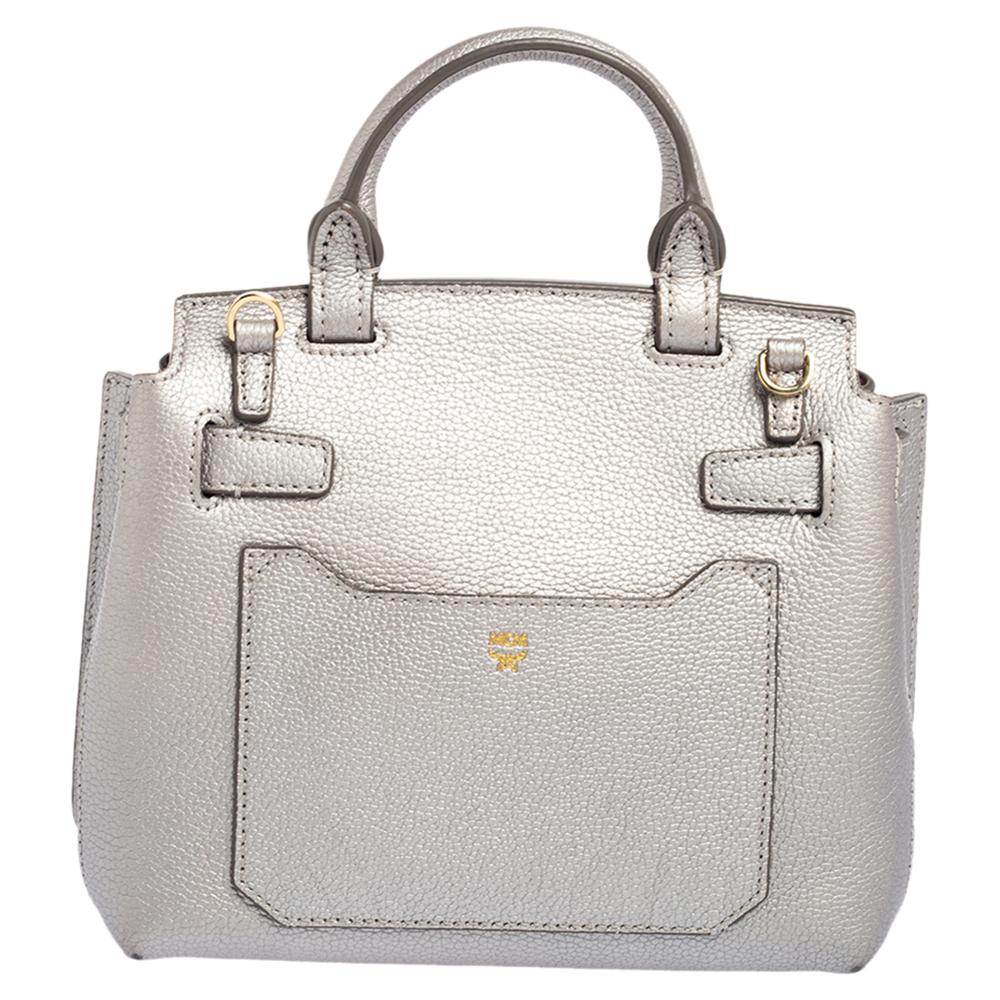 How elegant and lovely does this bag from MCM look! The silver bag is crafted from leather and features a top handle, a detachable shoulder strap, protective metal feet, and a front flap closure with a gold-tone twist lock. It opens to an