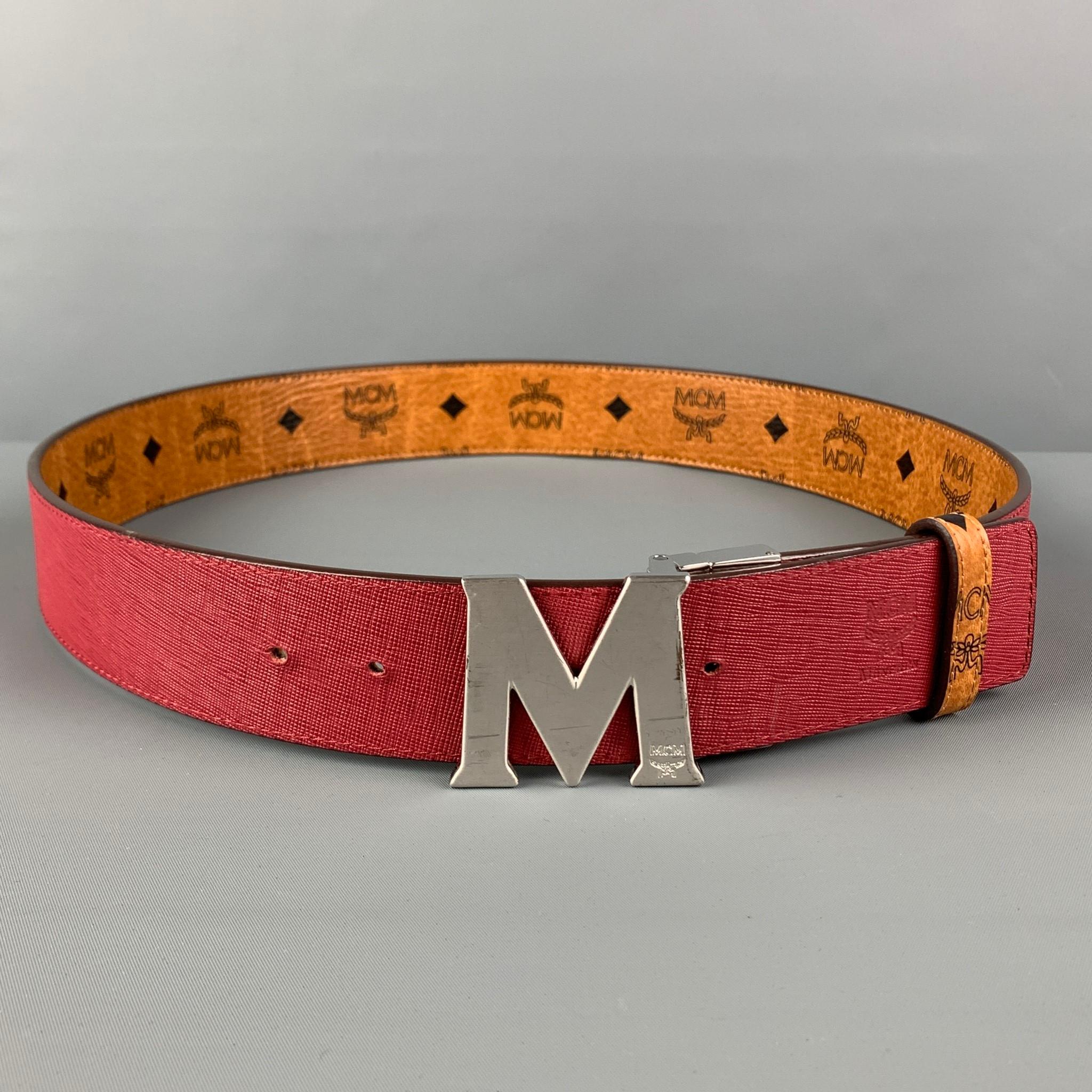 MCM belt comes in a tan & black monogram print leather featuring a burgundy reversible style and a silver tone logo buckle closure. 

Very Good Pre-Owned Condition.

Length: 43 in.
Width: 1.75 in.
Fits: 37 in. - 41 in.
Buckle: 1.75 in. 