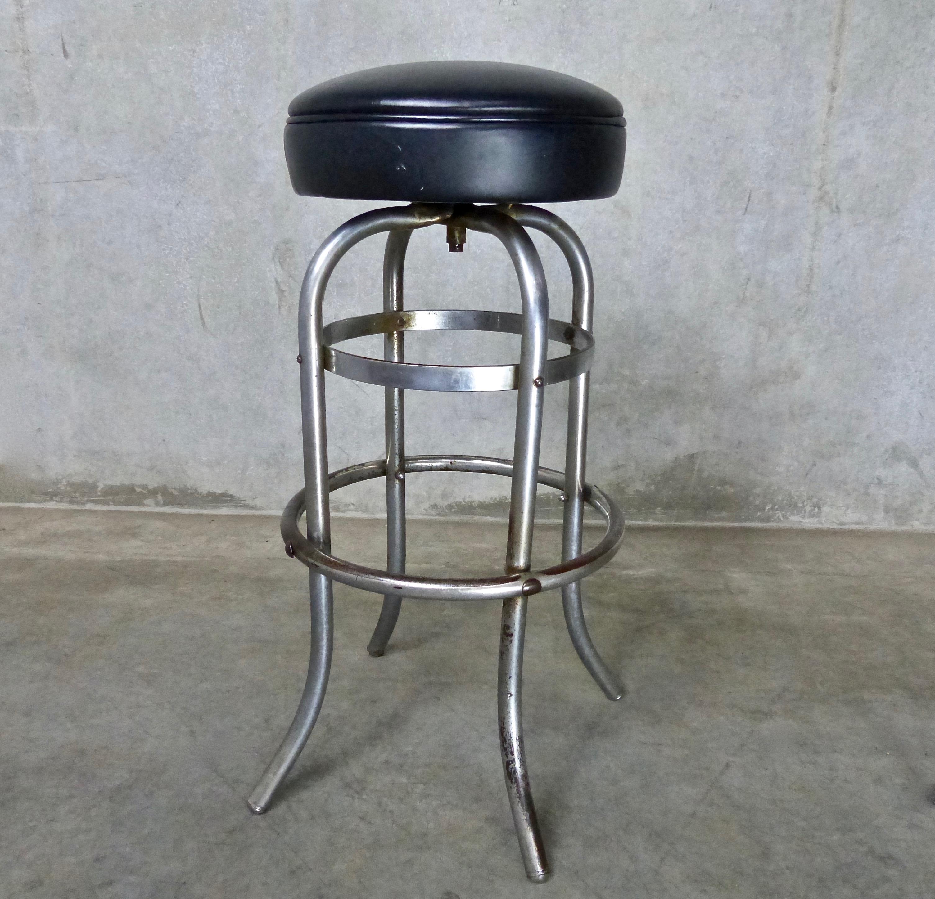 Matched pair of Mid-Century Modern, leather seat, four-legged chromed steel bar or counter stools. Made by Duro-chrome of St. Louis, Missouri. Nicely balanced, sturdy stools with well-worn foot rings. With padded, demountable swivel