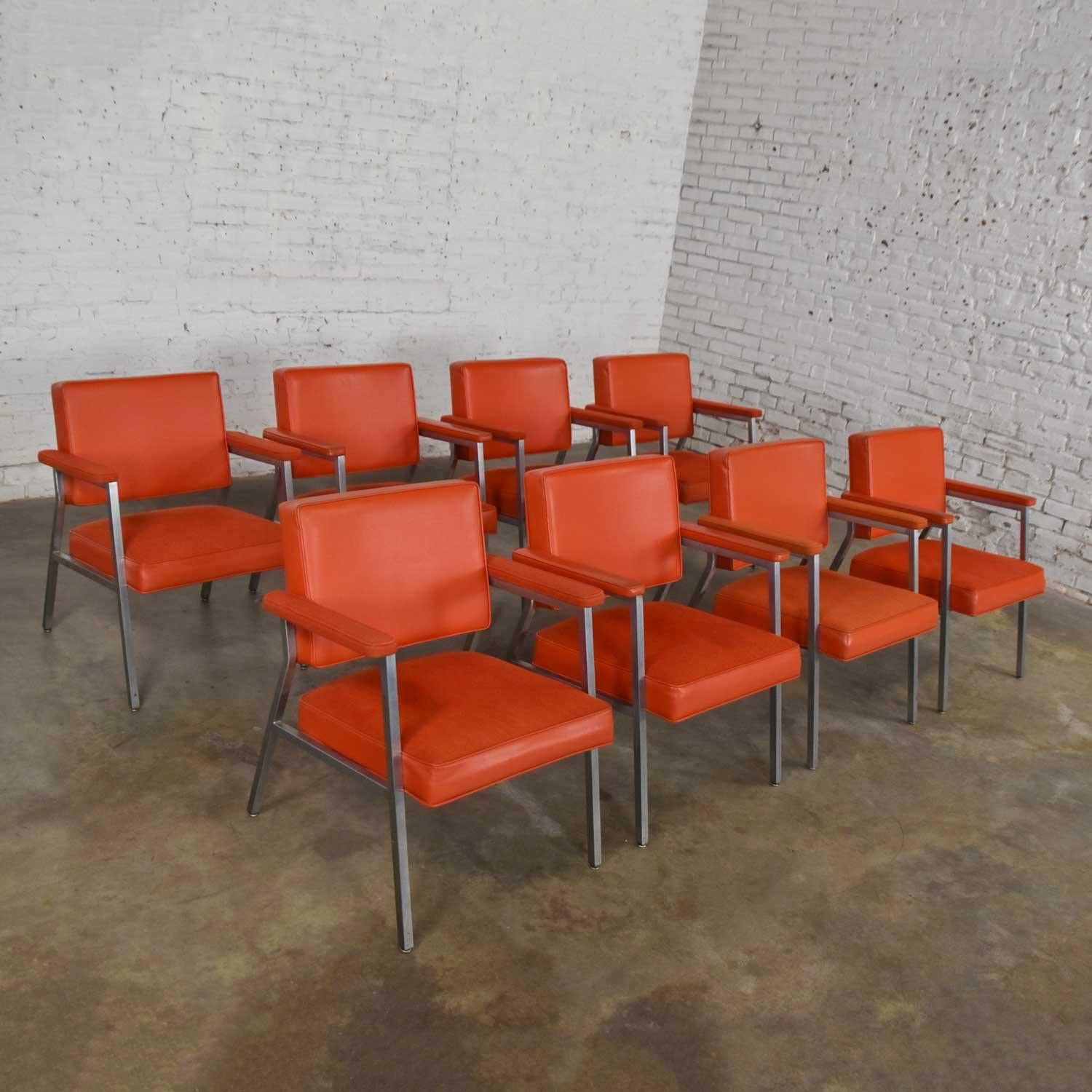 Outstanding Mid-Century Modern Steelcase coral dining armchairs set of eight. Comprised of polished steel, vinyl, and fabric in wonderful vintage condition. The foam in one seat cushion has Gotten a bit dry and will probably need replaced