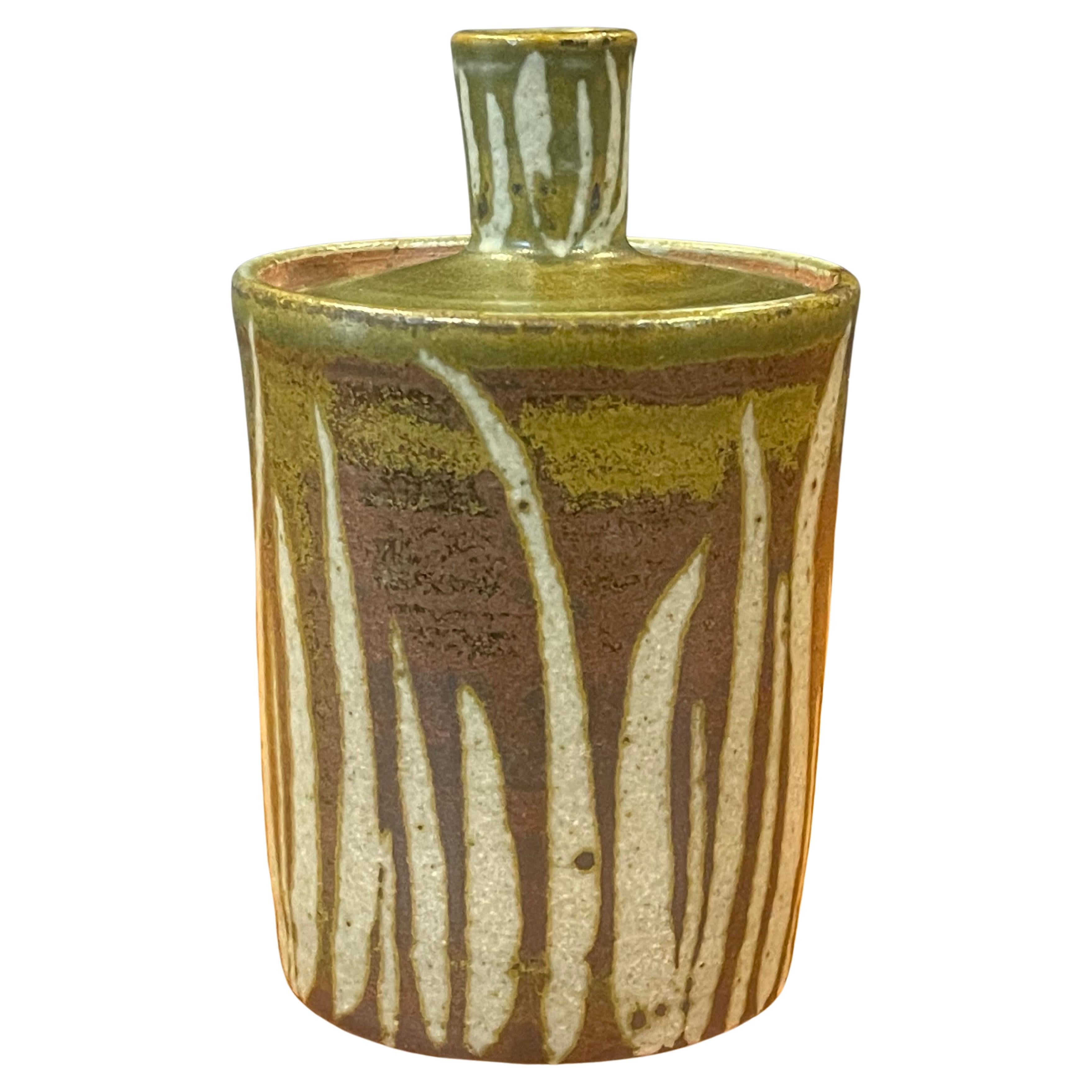 MCM stoneware studio pottery lidded jar by listed artist, Amy Donaldson, circa 1950s. This gorgeous hand finished jar has a wonderful design, texture and color. The piece measures 3.125