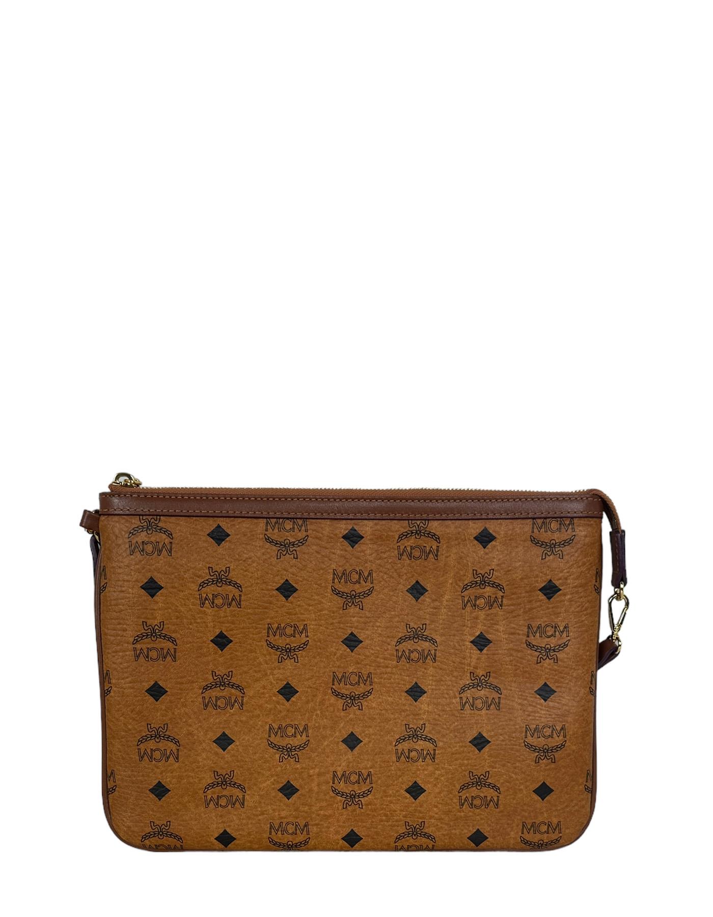 MCM Tan Visetos Monogram Pouch Bag. Strap can be moved to also be used as a wristlet
Made In: Korea
Color: Tan
Hardware: Goldtone
Materials: Coated canvas
Lining: Fine textile
Closure/Opening: Zip top 
Exterior Pockets: N/A
Interior Pockets: 