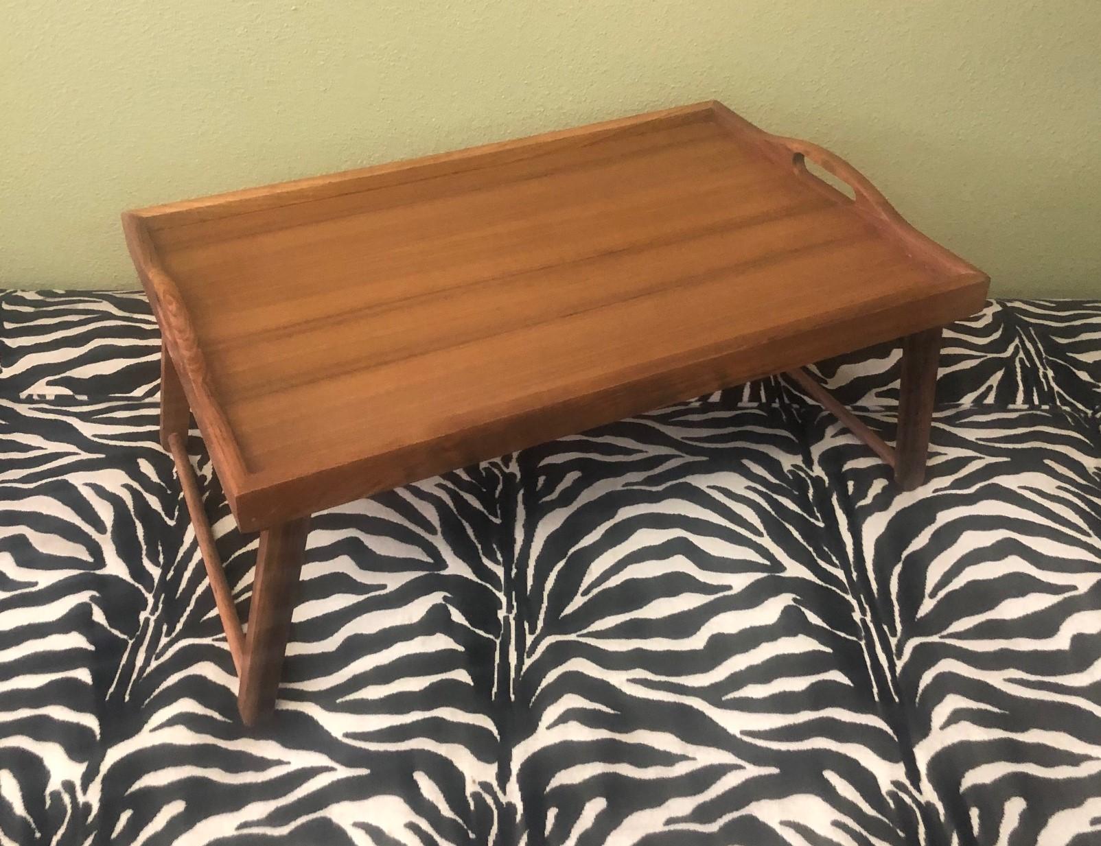 Mid-Century Modern teak foldable bed / breakfast tray, circa 1970s. Can be used for breakfast in bed with the two foldable legs down or as a regular serving tray with the legs in the up position. The piece measures 15.5