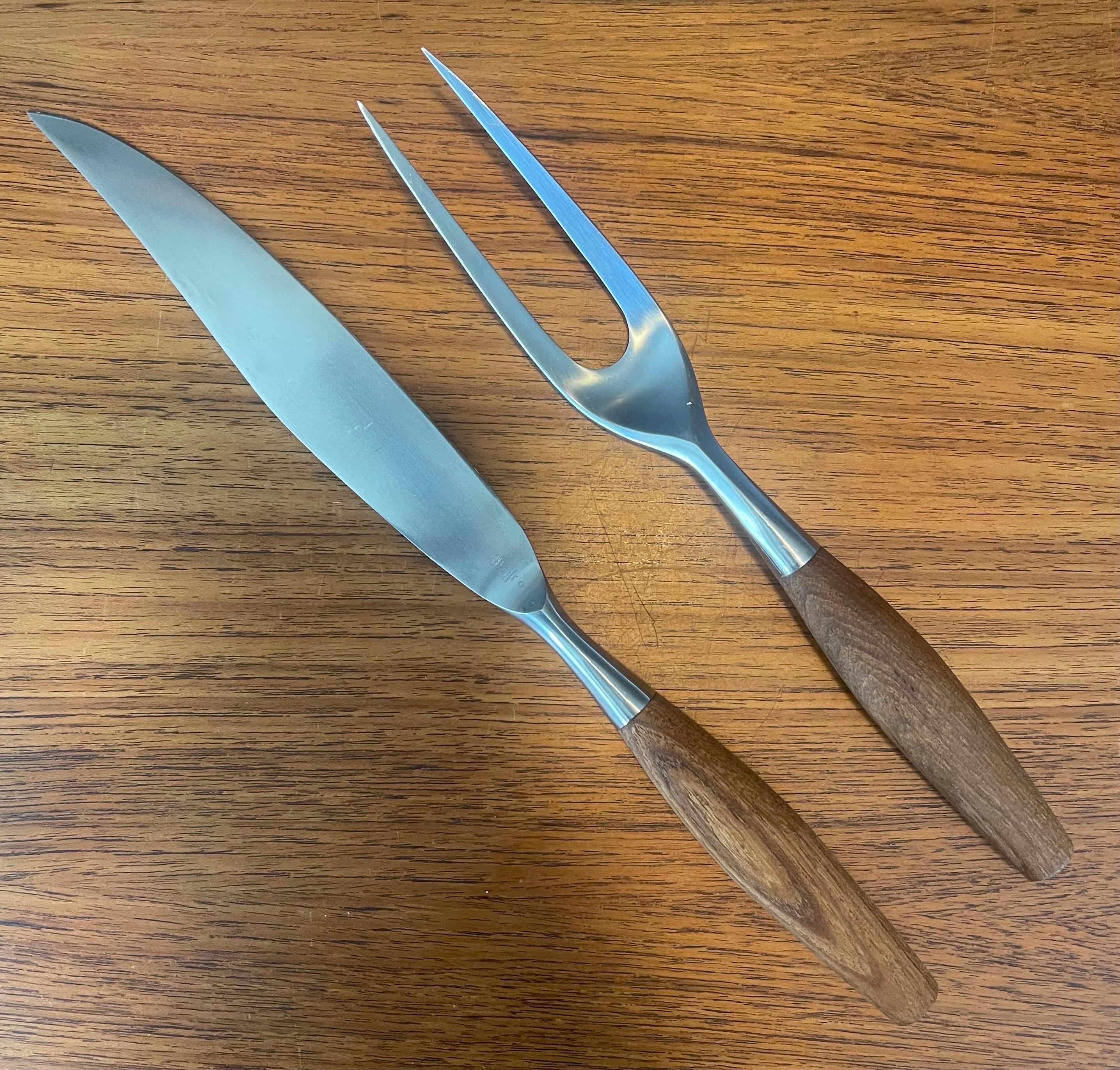 Stylish MCM teak and stainless steel carving set by Jens Quistgaard for Dansk, circa 1960s. The set includes a 14