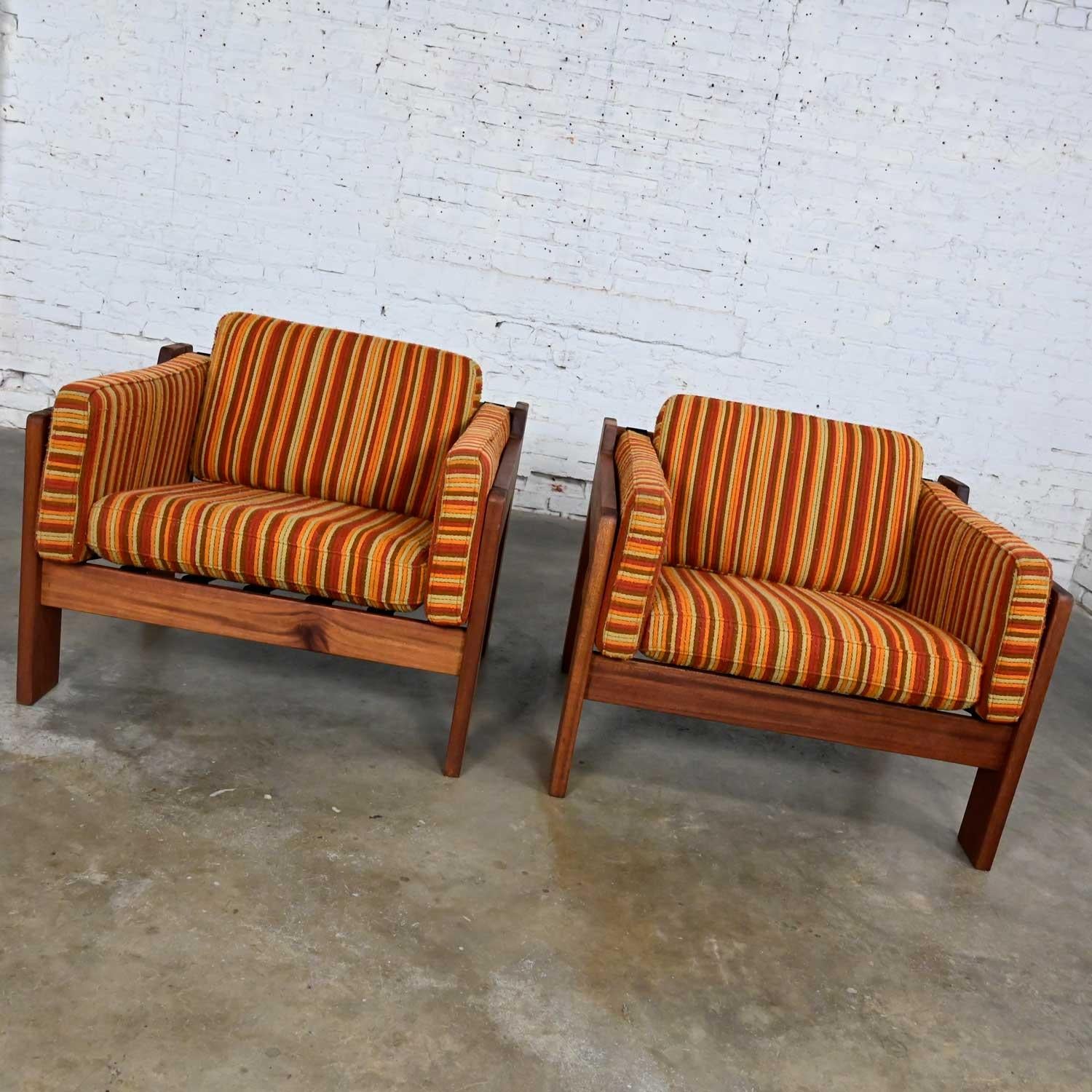 Beautiful vintage MCM or Mid-Century Modern to Modern club chairs comprised of teak frames with metal seat body straps and 4 loose cushions with their original orange striped fabric in the style of Tobia Scarpa or Lou Hodges. Beautiful condition,