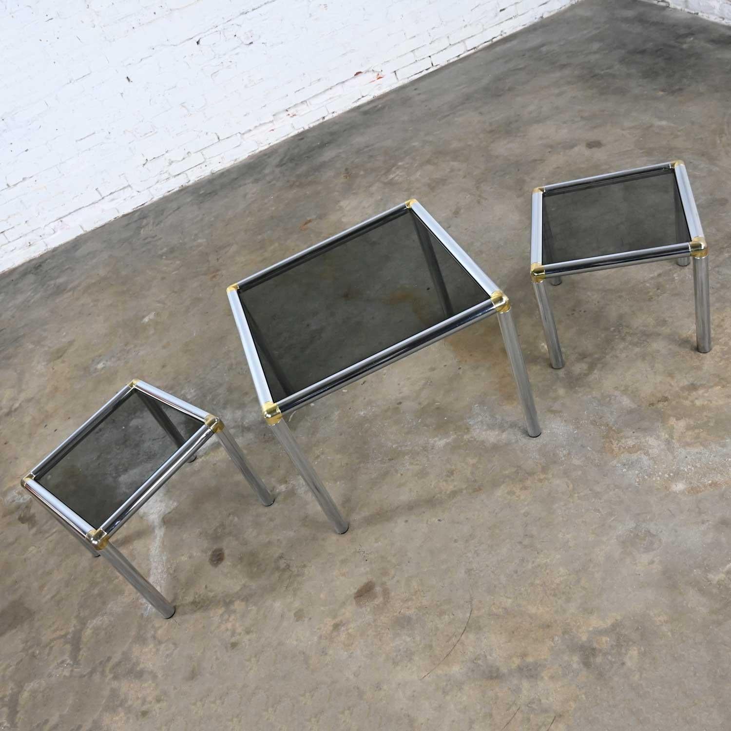 Awesome trio of matching MCM, Mid-Century Modern, to modern tubular chrome frame tables, one cocktail and two end tables with brass accents and smoke glass tops. Wonderful condition, keeping in mind that these are vintage and not new so will have