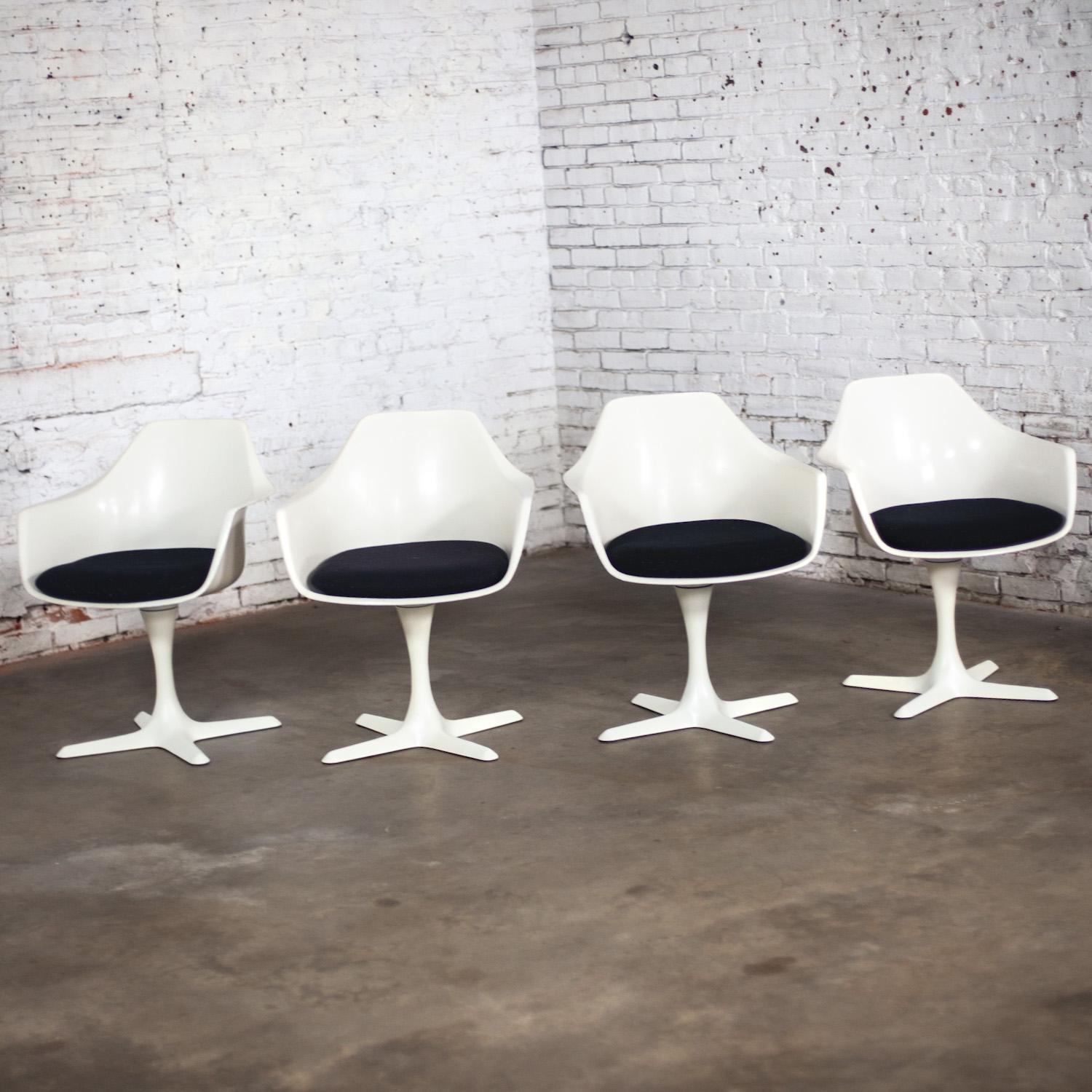 Awesome Mid-20th Century Mid Century Modern Tulip chairs by Burke comprised of a white fiberglass armed shell or frame, white painted metal shaft, 4 prong fiberglass bases, & loose cushion pads with black hopsacking, set of 4. Beautiful condition,
