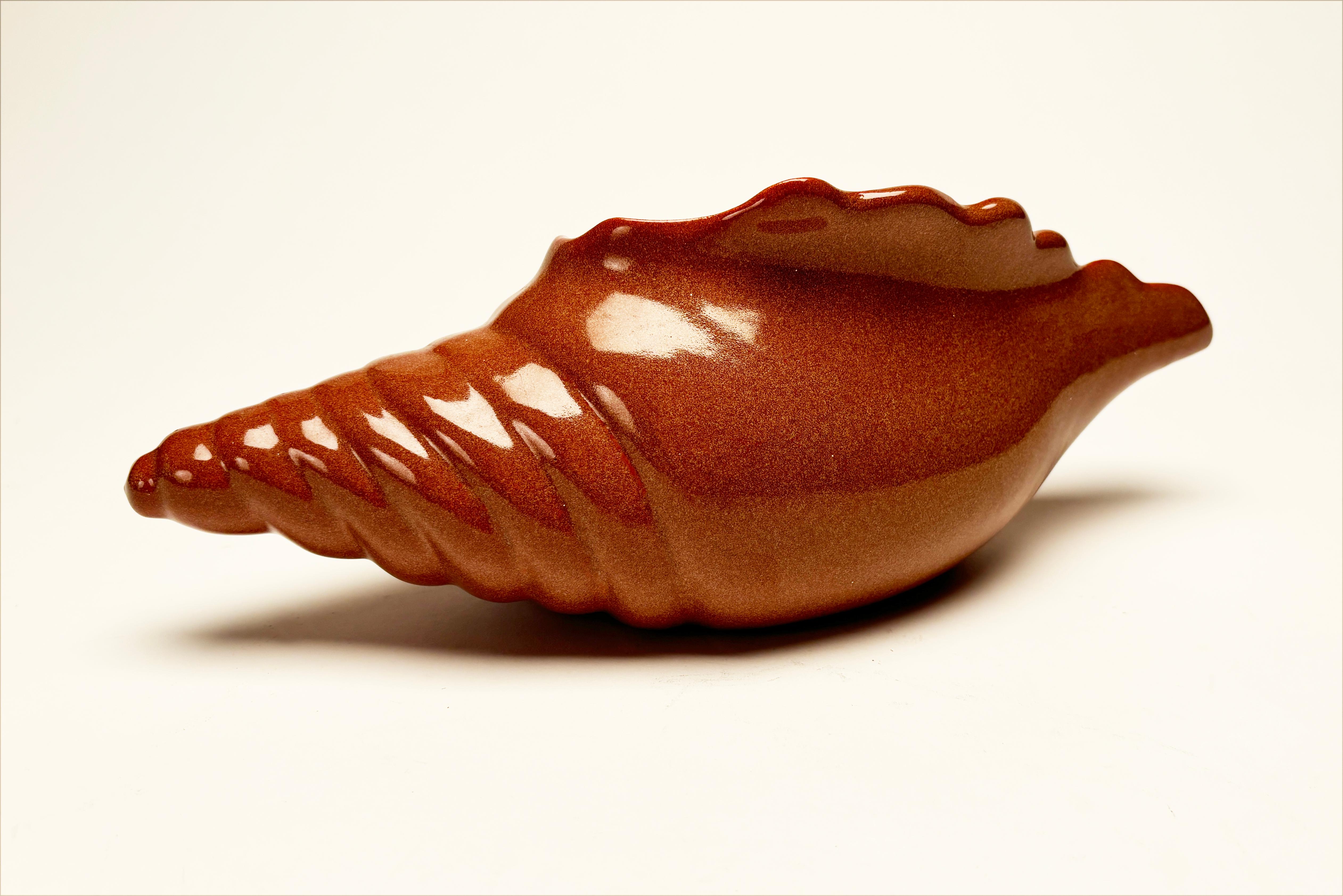 Les amateurs de poterie trouveront cette pièce d'un grand intérêt. Créé par Van Riggle au milieu du 20e siècle, ce motif unique de coquille de conque est réalisé dans une riche couleur citrouille avec une belle glaçure pour compléter l'aspect. Des