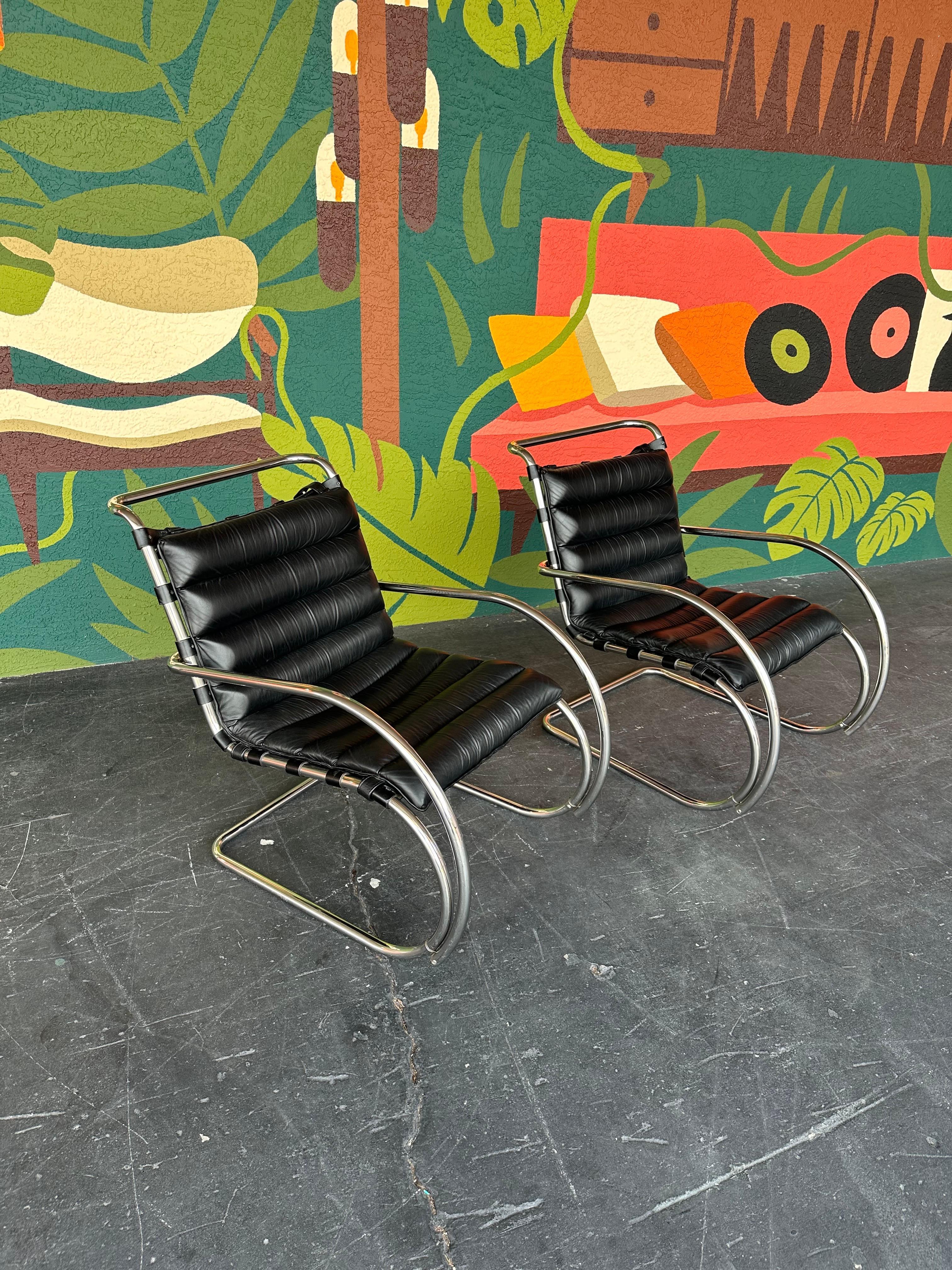 Pair of vintage Mies Van Der Rohe for Knoll black leather and chrome cantilevered lounge chairs with armrests. Iconic timeless bauhaus era design, comfortable, attractive and would blend nicely with a variety of design styles.

Original black