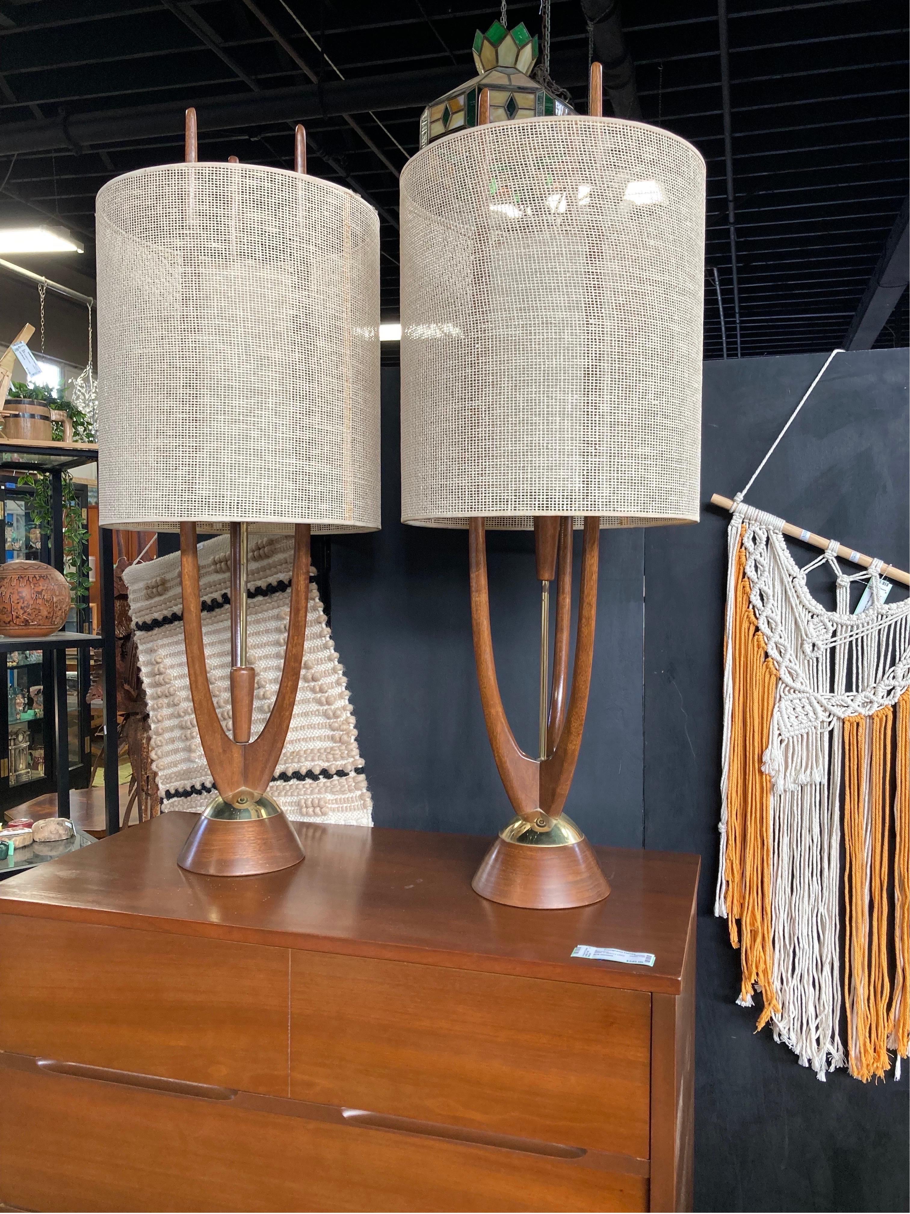 This gorgeous, tall pair of walnut Modeline of California Mid-Century Modern lamps dates to the 1960s. Each measures 40” tall. A carved, rounded piece of walnut wood is attached to a beaded pulley which, when pulled down, softly turns the light on