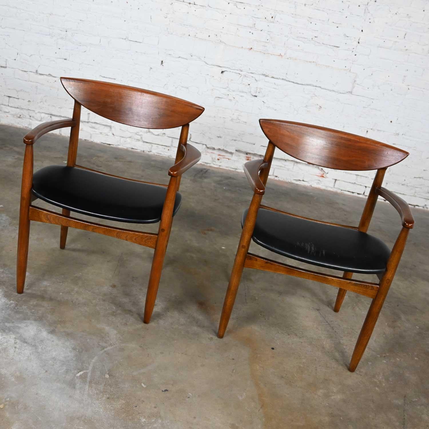Fabulous vintage MCM (a.k.a. Mid-Century Modern) pair of host & hostess dining arm chairs by Warren Church for Lane Perception comprised of oak frames with walnut backs and black vinyl faux leather seats. Beautiful condition, keeping in mind that