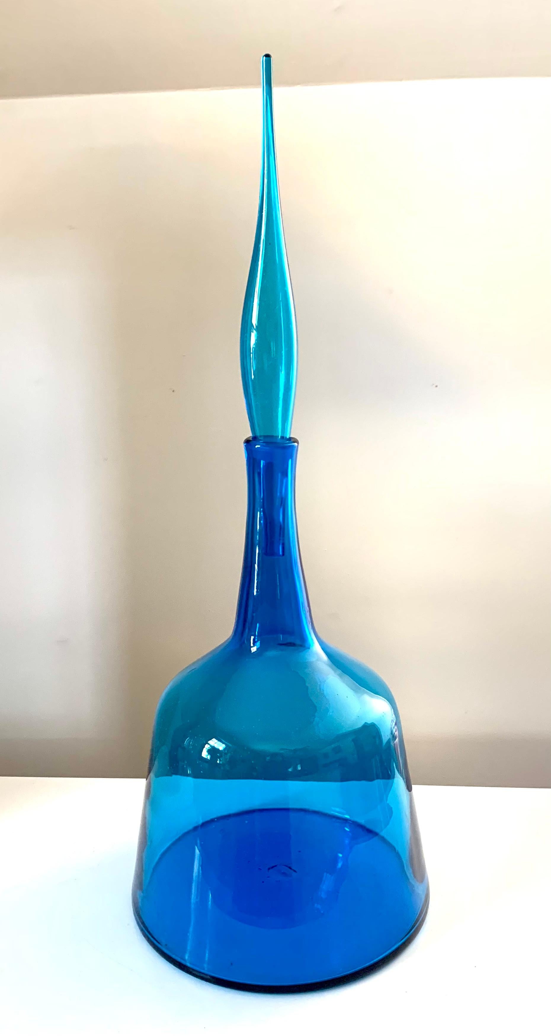 Mid Century Modern Wayne Husted for Blenko large turquoise flame stoppered floor decanter with original paper label intact.
#6122L
Excellent condition
Beautiful vibrant color, handblown, fluid elegant shape.