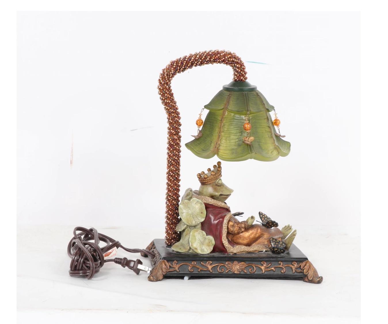 most adorable resin frog figure with faux jeweled crown and princely cape, reclining on lily pads with butterflies about him, all under a resin gradated green translucent articulated lily flower shade with hanging faux beads and gold butterfly