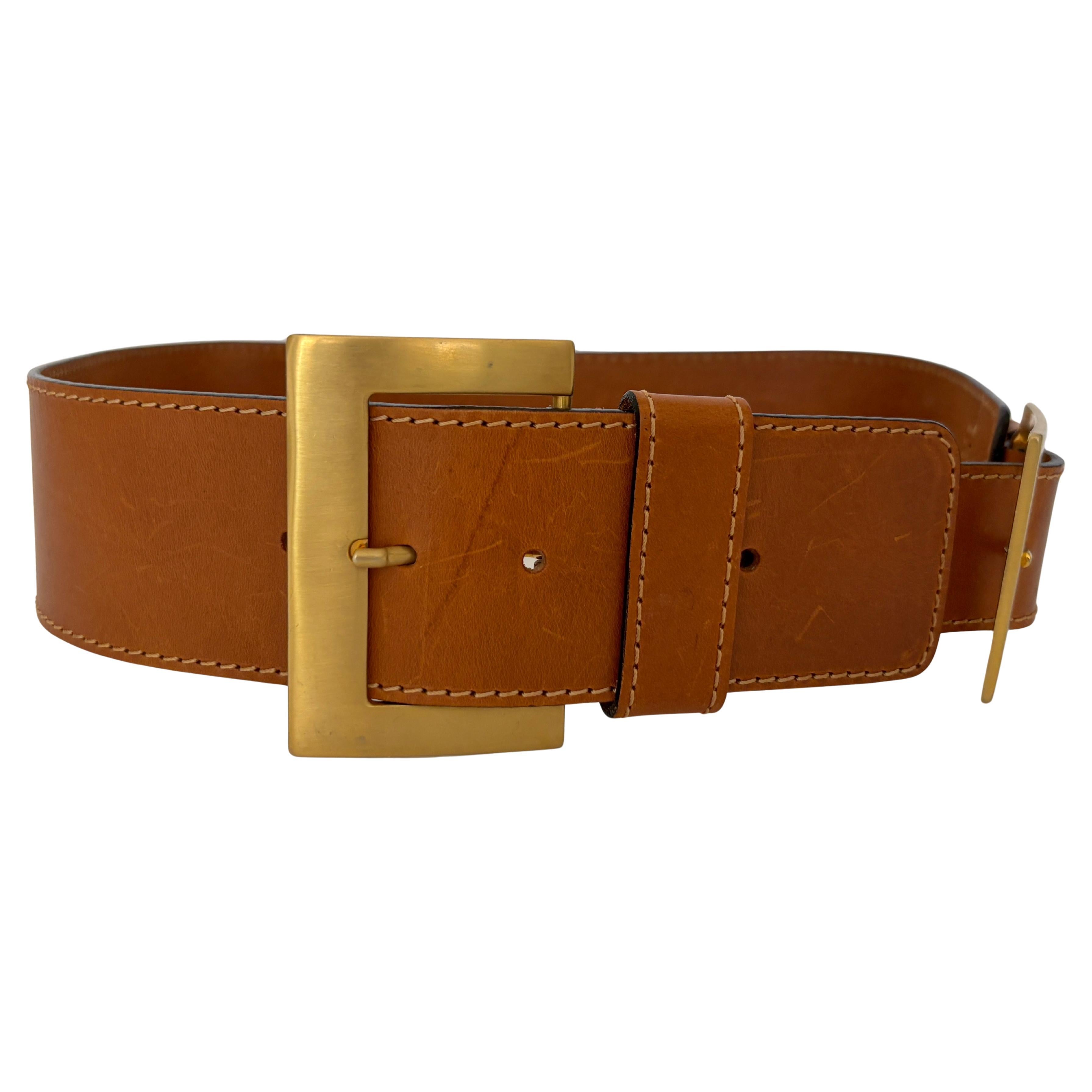 Vintage MCM Wide Tan Brown Leather Waist Belt with Dual Gold Buckles, Made in Italy
This vintage MCM women’s leather waist belt is a striking statement accessory, crafted in tan brown leather and accented with two bold gold-tone square buckles. A