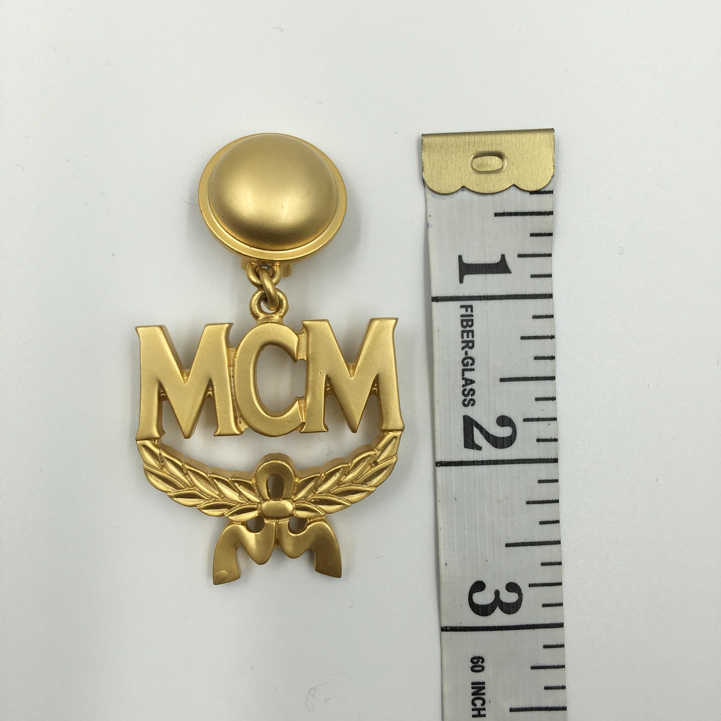 MCM Wreath Logo Matte Gold Tone Clip On Earrings In Good Condition For Sale In Los Angeles, CA