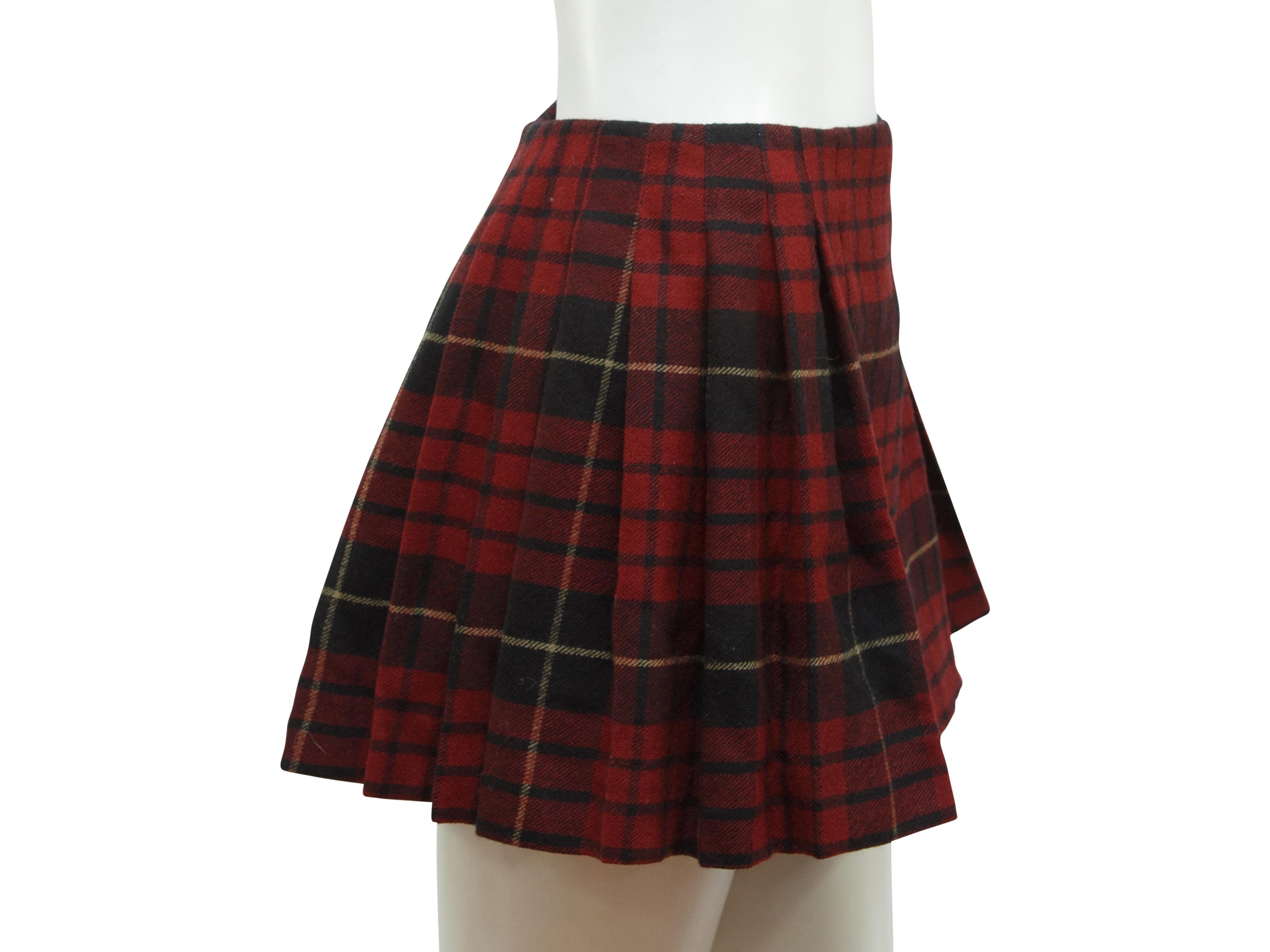 Product details:  Red tartan plaid mini kilt skirt by McQ Alexander McQueen.  Trimmed with black leather.  Adjustable double buckle closure.  Pleated back.  Label size IT 38.  27