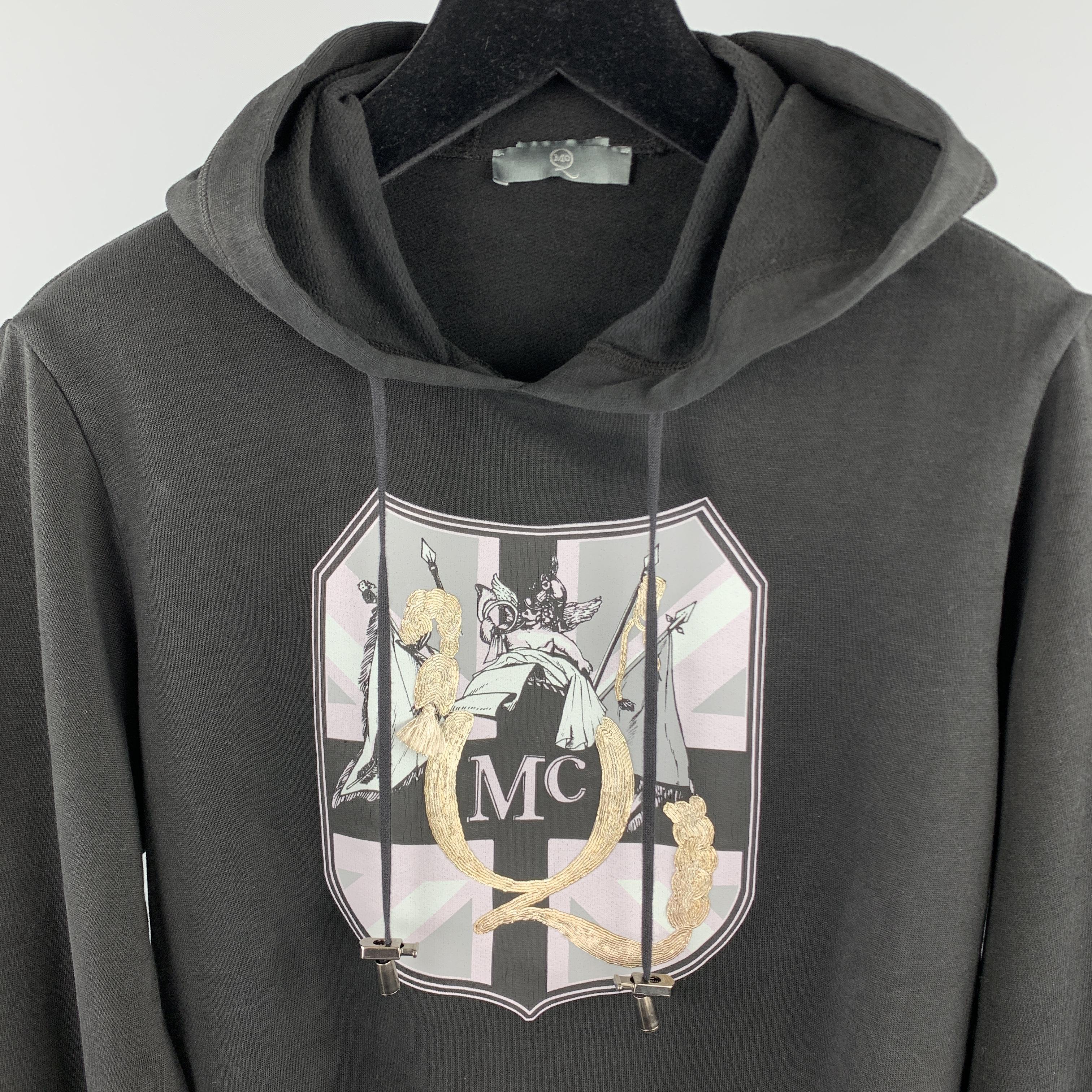 MCQ by ALEXANDER MCQUEEN sweatshirt comes in a solid black cotton material, featuring a hood, a graphic and embellishment at chest, silver tone metal hardware, and ribbed cuffs and hem. Made in Italy.

Very Good Pre-Owned Condition.
Marked: US