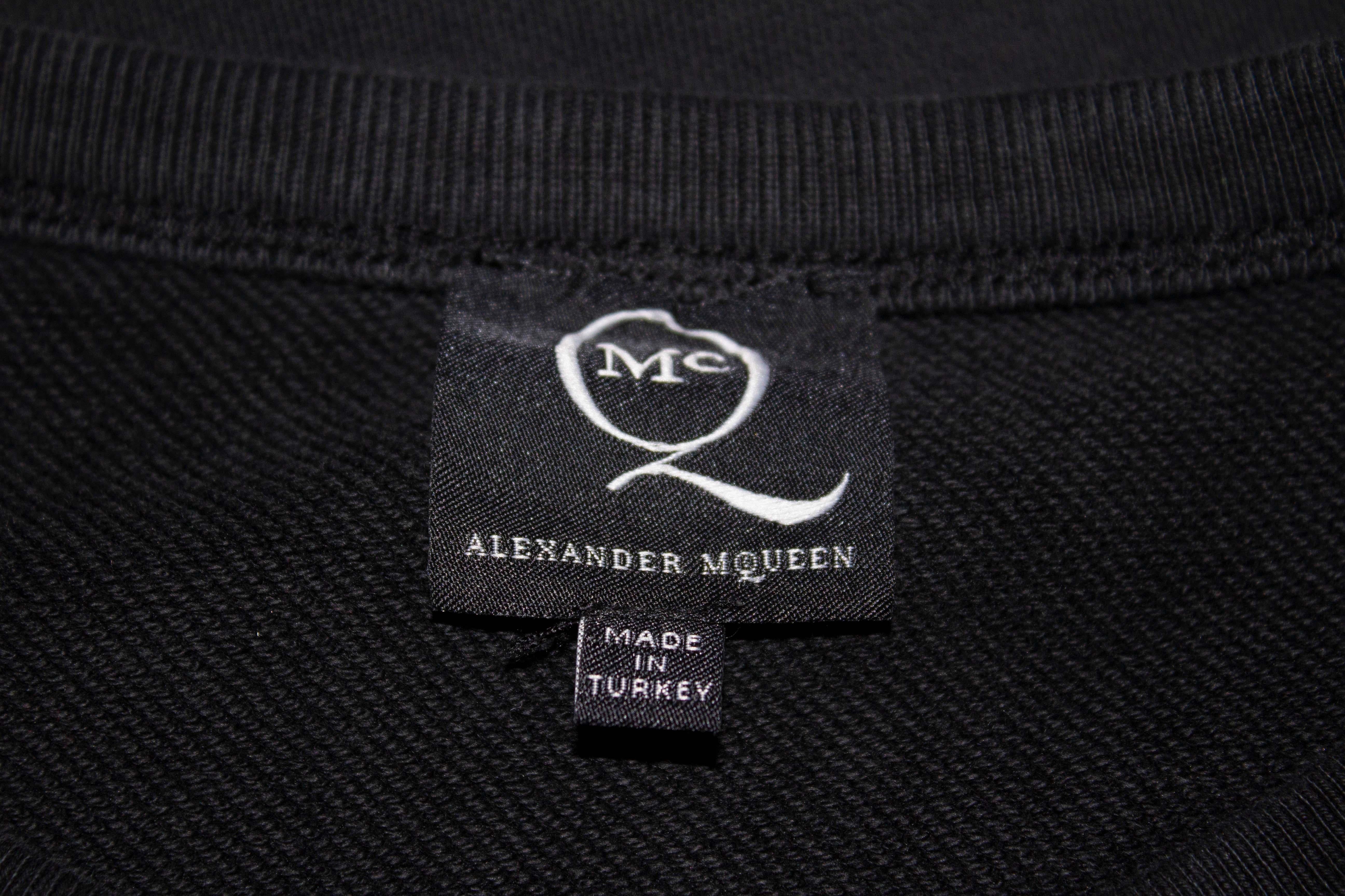 A fun sweatshirt by Alexander McQueen, McQueen line. The shirt has a round neckline, black background , ribbed hem and cuffs and logo on the front. 100 %  cotton.
Measurements: Bust up to 38'', length 23''