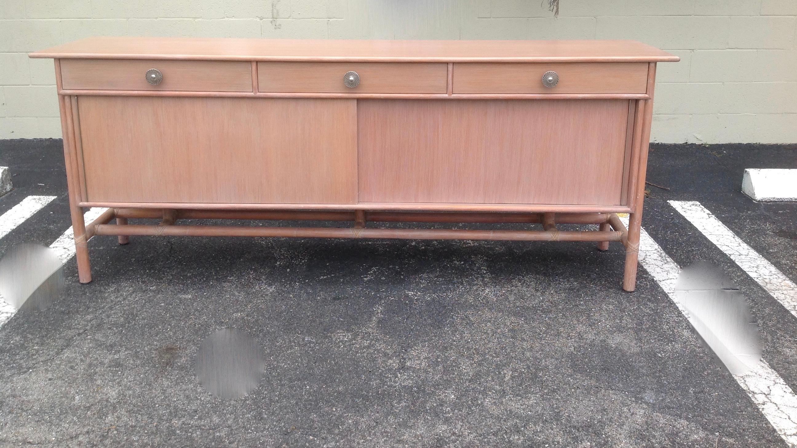 Credenza or buffet for Baker's McGuire division features leather-wrapped bamboo legs and trim. It is accented with a 