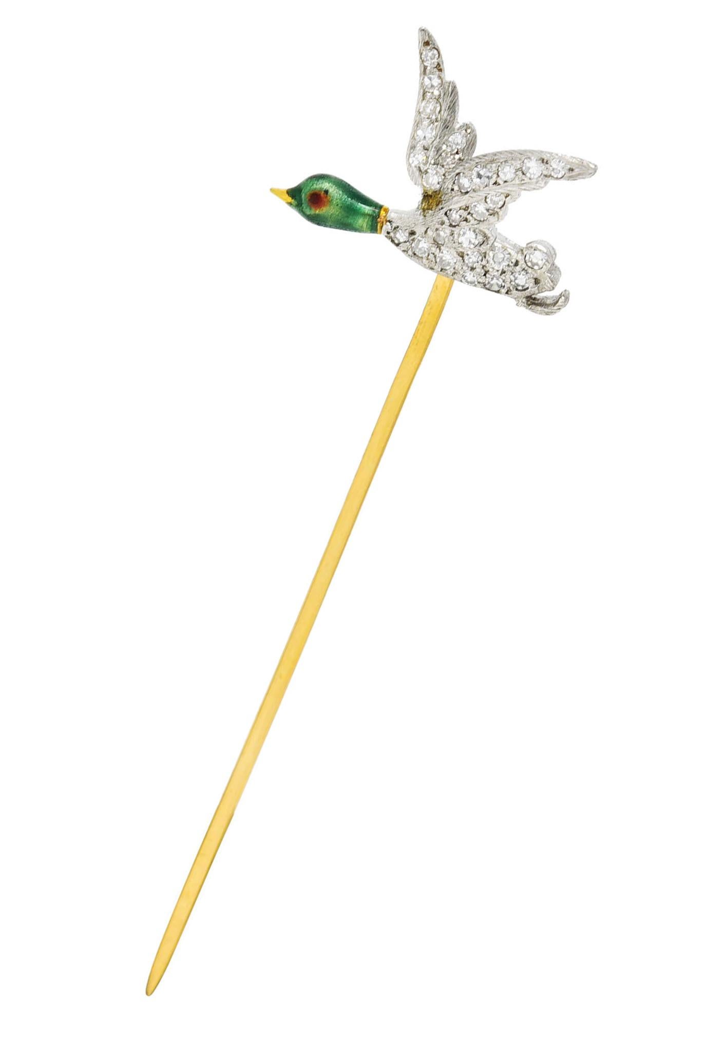 Stickpin is designed as a flying mallard duck with yellow gold beak and enamel painted head. Transparent bright green with a transparent red eye - exhibiting minimal loss. With a platinum winged body - pavè set with single cut diamonds throughout.