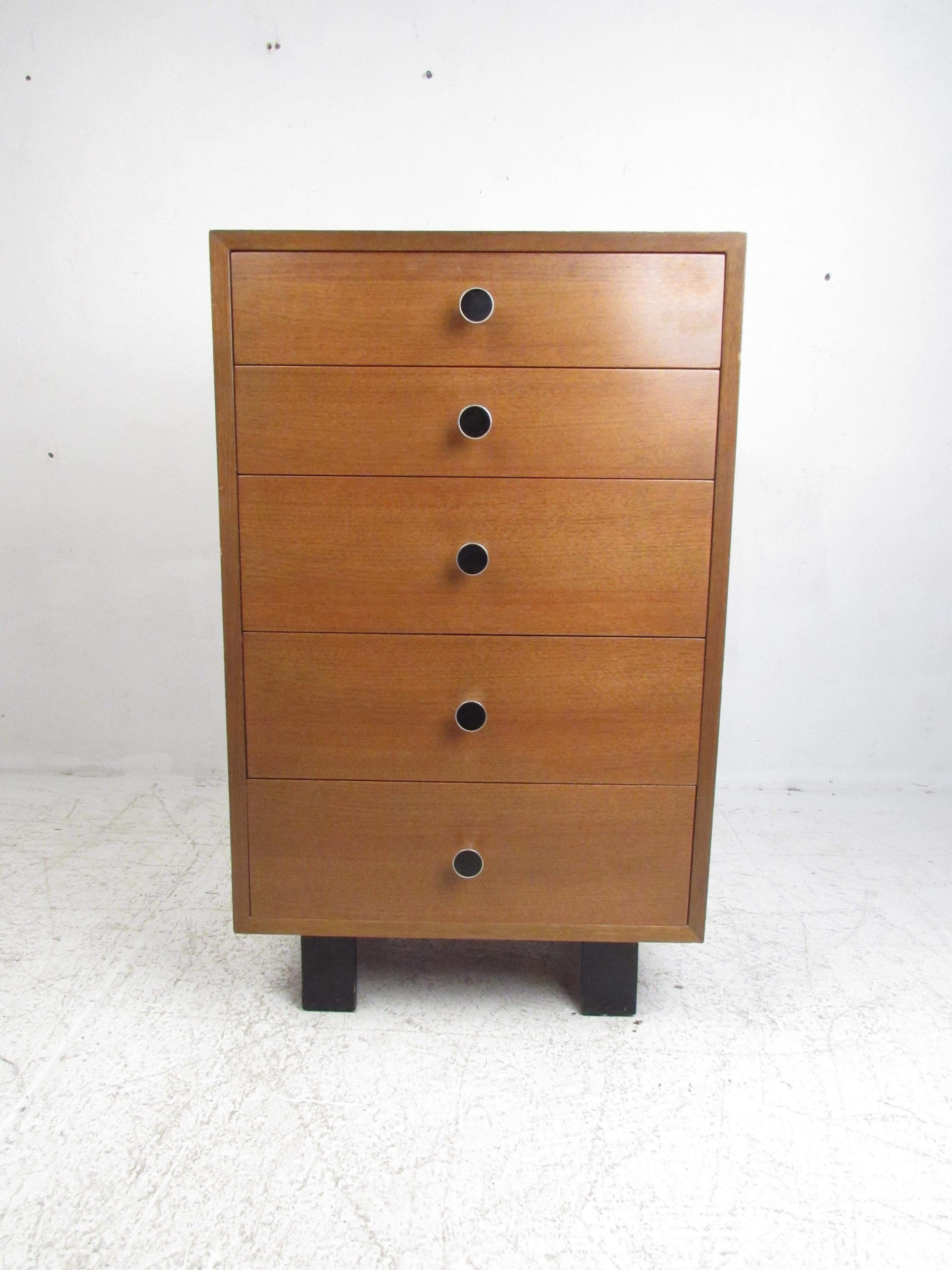 This stunning vintage modern lingerie chest features sculpted round pulls with ebonized fronts on each drawer. This stylish five-drawer chest offers plenty of room for storage within its compact design. The unusual legs show attention to detail and