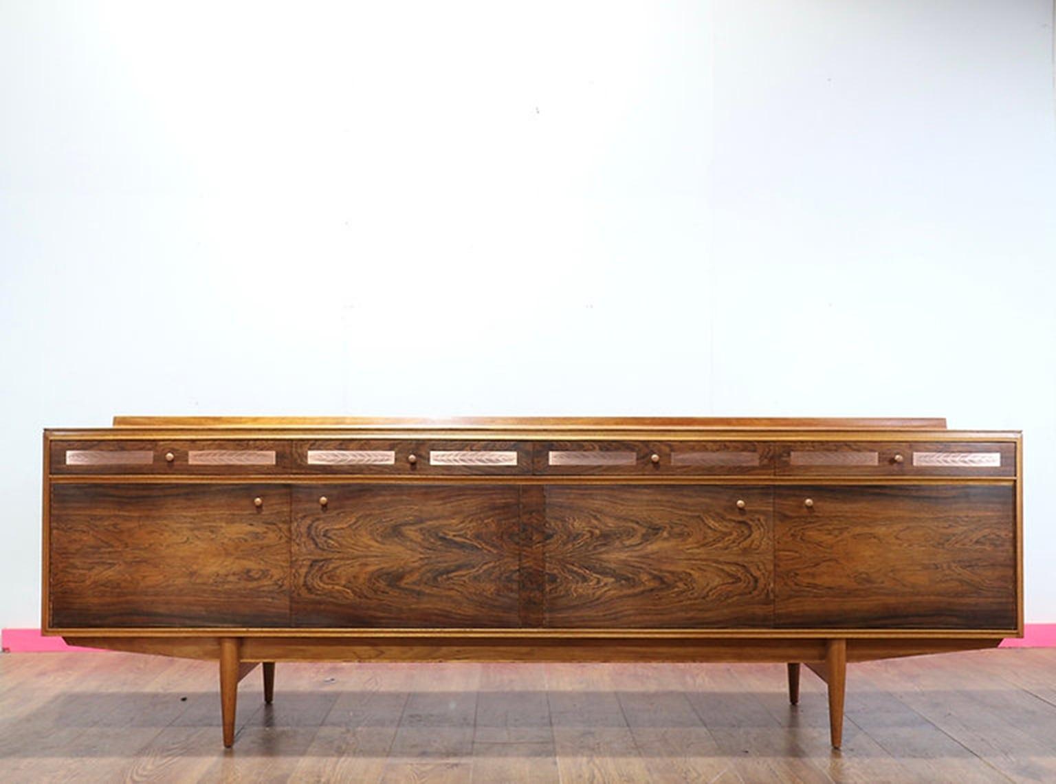 Entdecken Sie die atemberaubende Eleganz dieser atemberaubenden Kredenz, die von Archie Shine entworfen und von Robert Heritage hergestellt wurde und exklusiv bei Mid Century Traders erhältlich ist. Die wunderschöne Maserung aus Palisander und