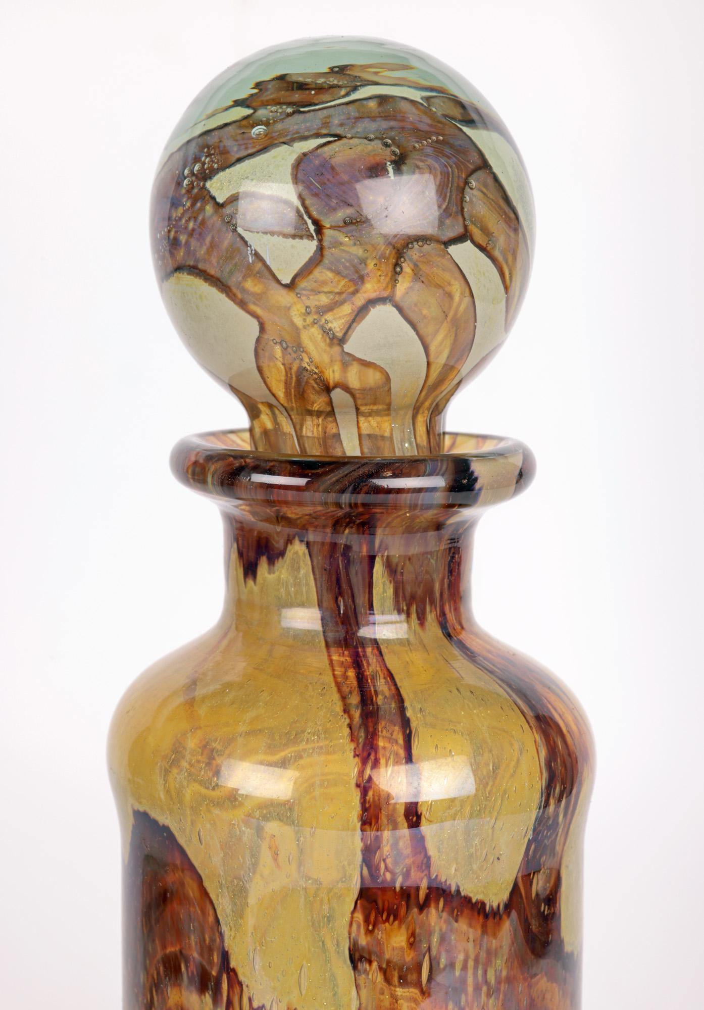 A tall and exceptional Maltese art glass decanter and stopper with a brown abstract swirl design made at Mdina and designed by Michael Harris in the early 1970’s. The hand-blown glass decanter is of tall cylindrical shape with a slight widening at