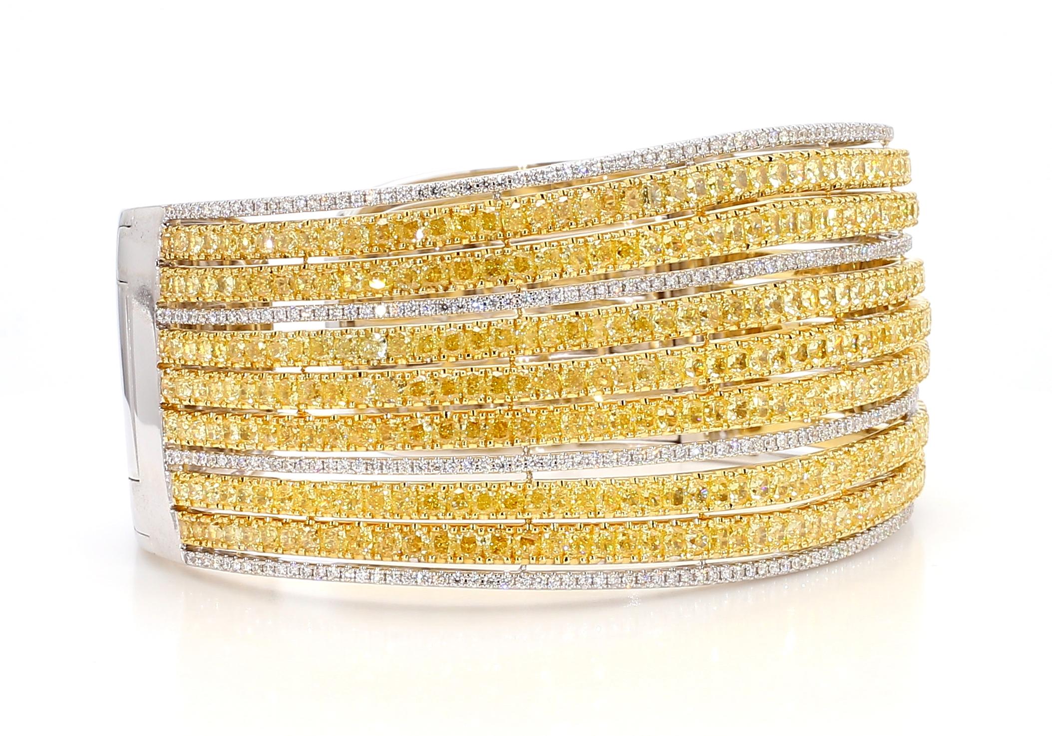 This Fancy Vivid Yellow Bangle with 7 calibrated cushion vivid yellow diamond rows is a testament to fine craftsmanship and timeless design. 

Perfect for those who appreciate the beauty of fancy color & natural diamonds, this bangle offers a