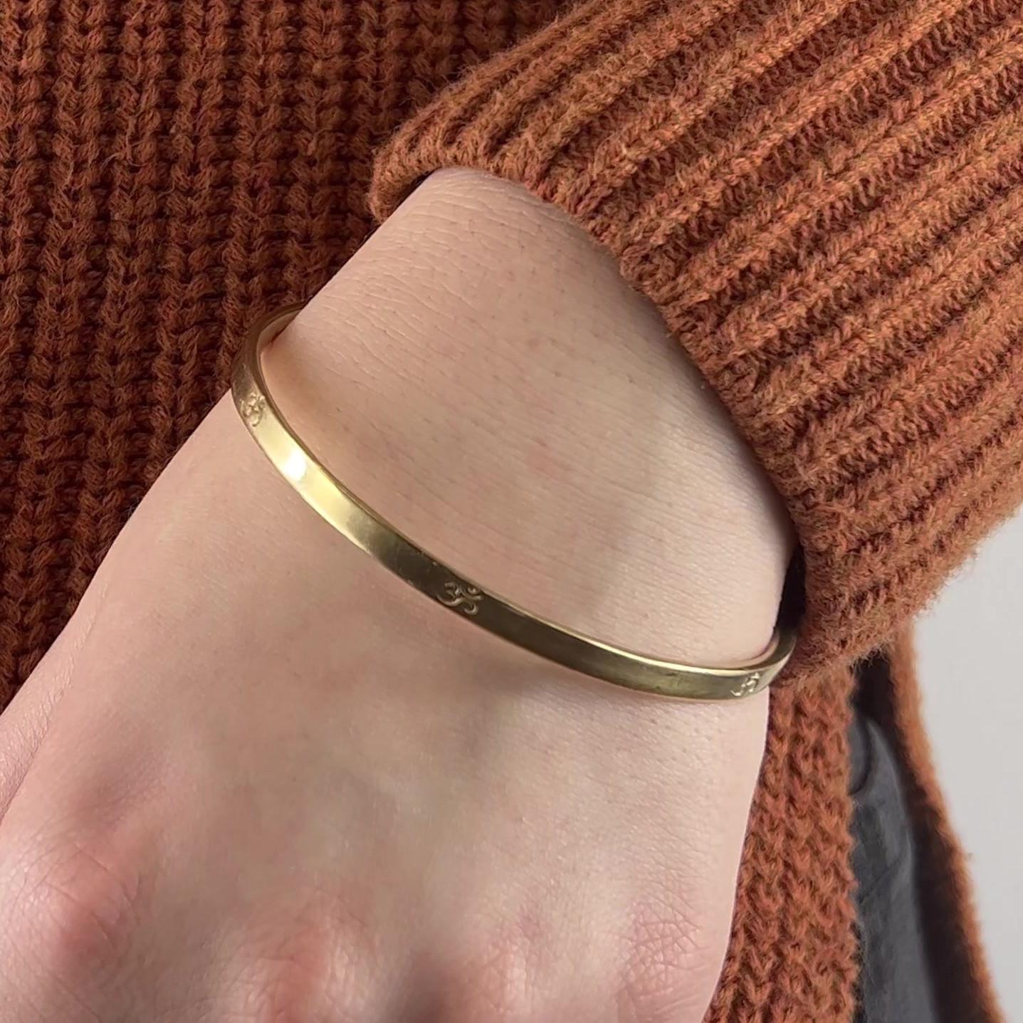 One Me & Ro Yellow Gold OM Bangle Bracelet. Crafted in 10 karat yellow gold, signed Me & Ro. Circa 2010s. The bracelet measures 8 1/2 inches in length. 

About this Item: Add a touch of modern sophistication to your jewelry collection with this