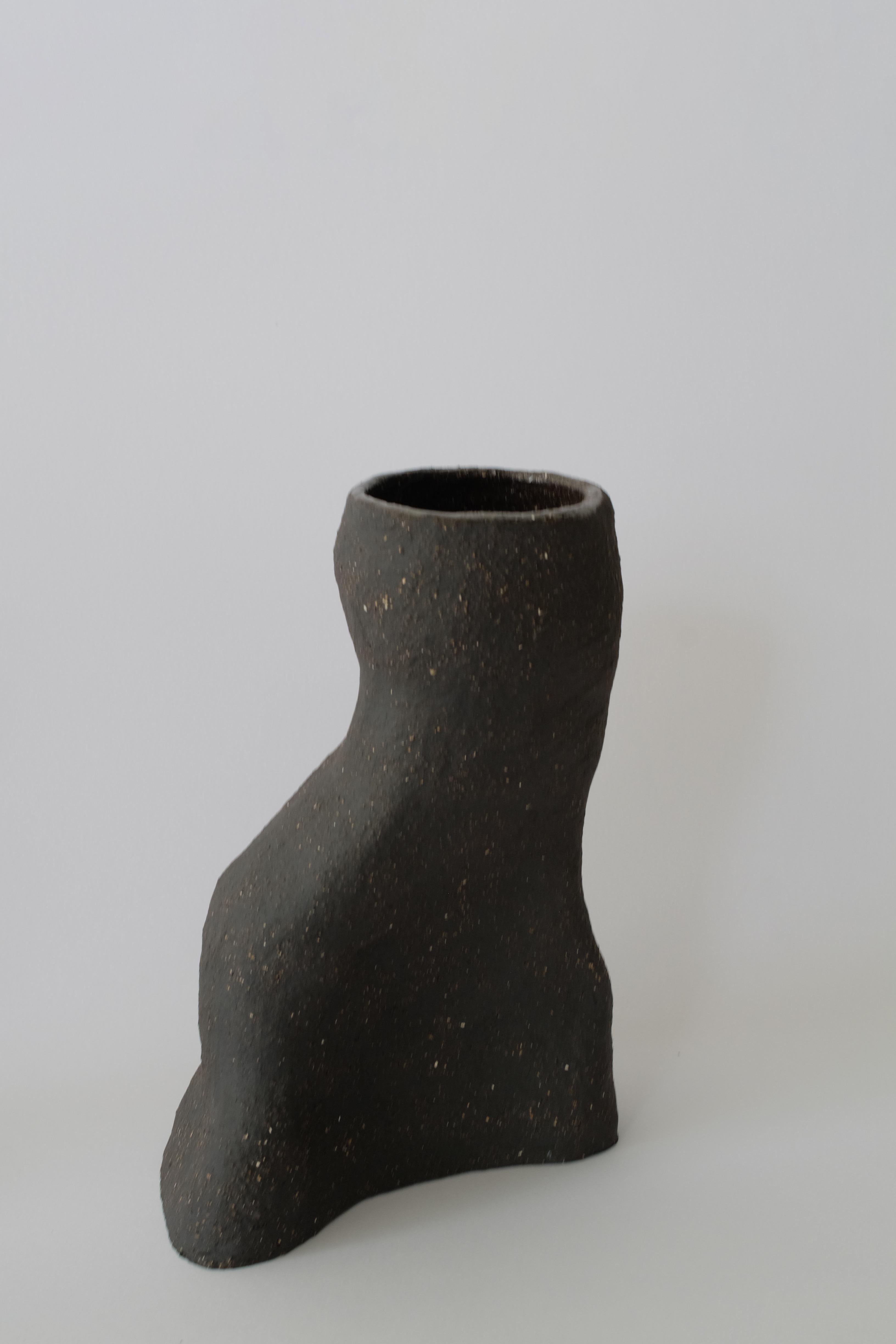 Meander Granite vase by Sophie Parachey
Dimensions: W 23 x D 14 x H 33 cm
Materials: Black textured stoneware (large chamotte).

Inspired by extended stays in Central America, Sophie Parachey’s work questions transformation, the antagonism