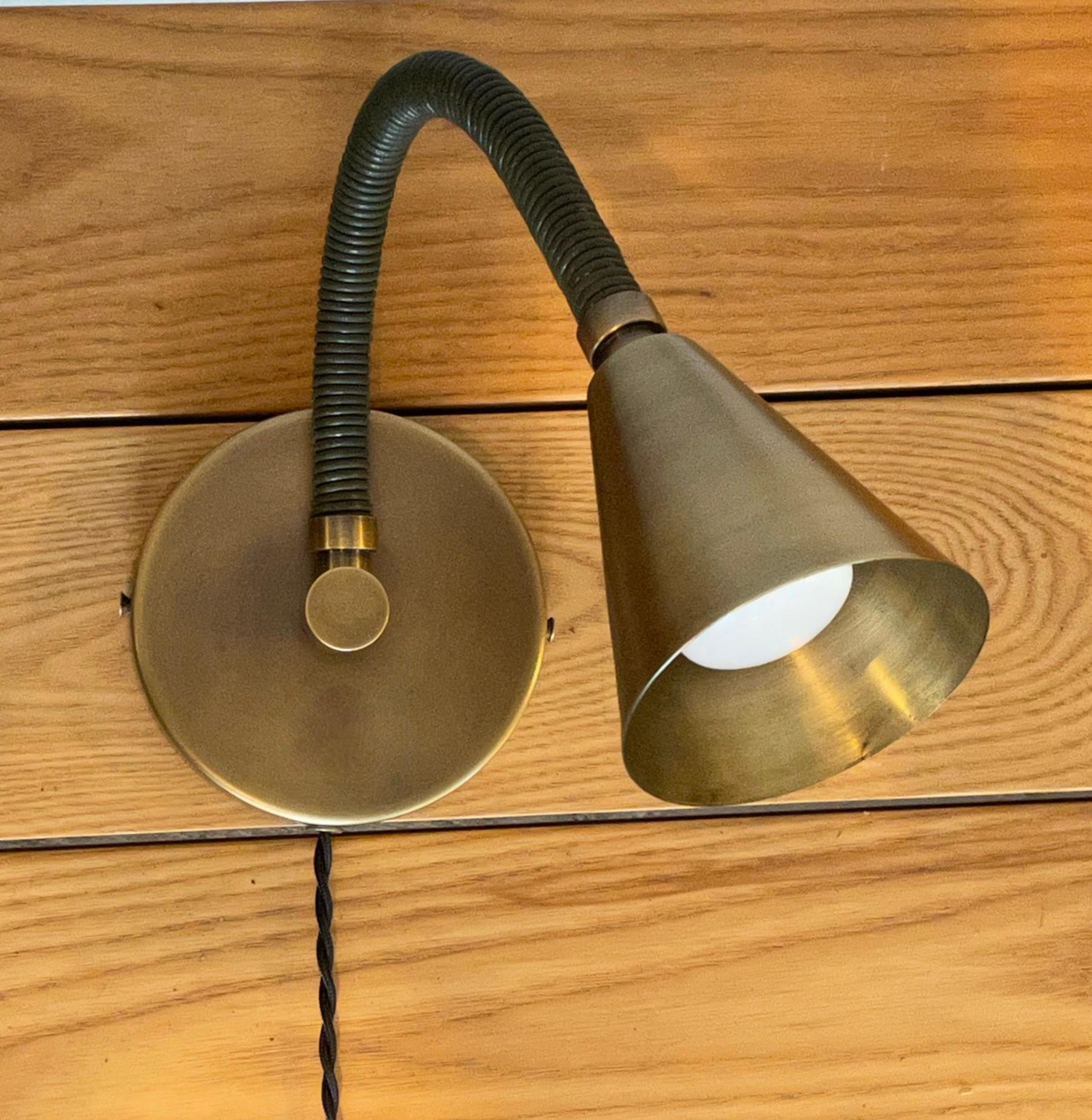 Version enfichable de notre applique simple Meander -- lampe murale à bras flexible enveloppée de cuir que vous pouvez poser et ajuster à votre guise. Il s'agit de notre lampe de lecture Meander mise à jour avec un abat-jour conique plus grand et un
