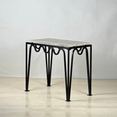 Mesa auxiliar 'Méandre' de hierro negro y travertino plateado de Design Frères