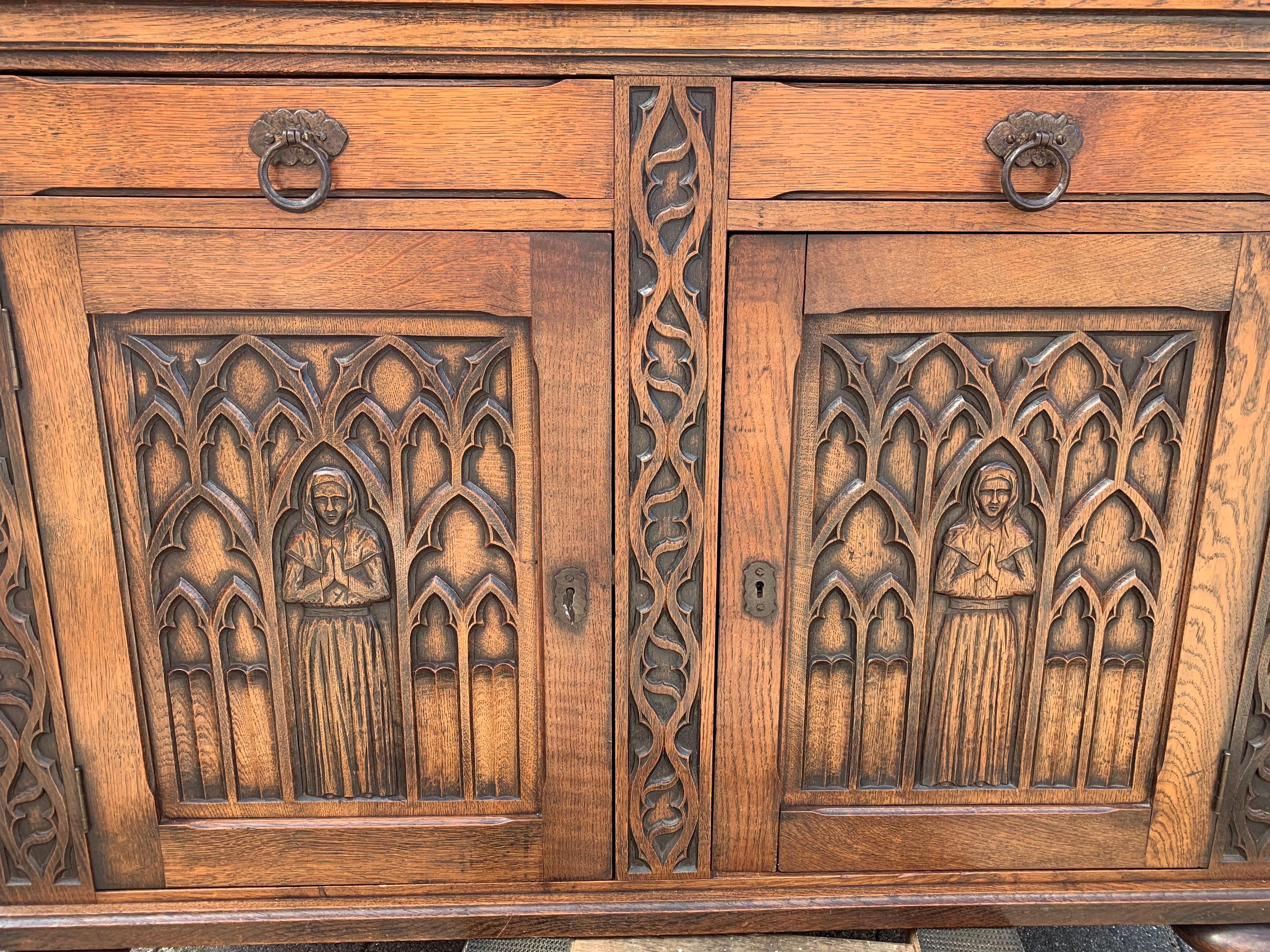 Early 20th century, solid oak Gothic cabinet with hand carved church window panels.

This beautifully and deeply carved oak cabinet from the early 1900s is in excellent condition. It comes with Fine quality, hand carved details and the warmest ever