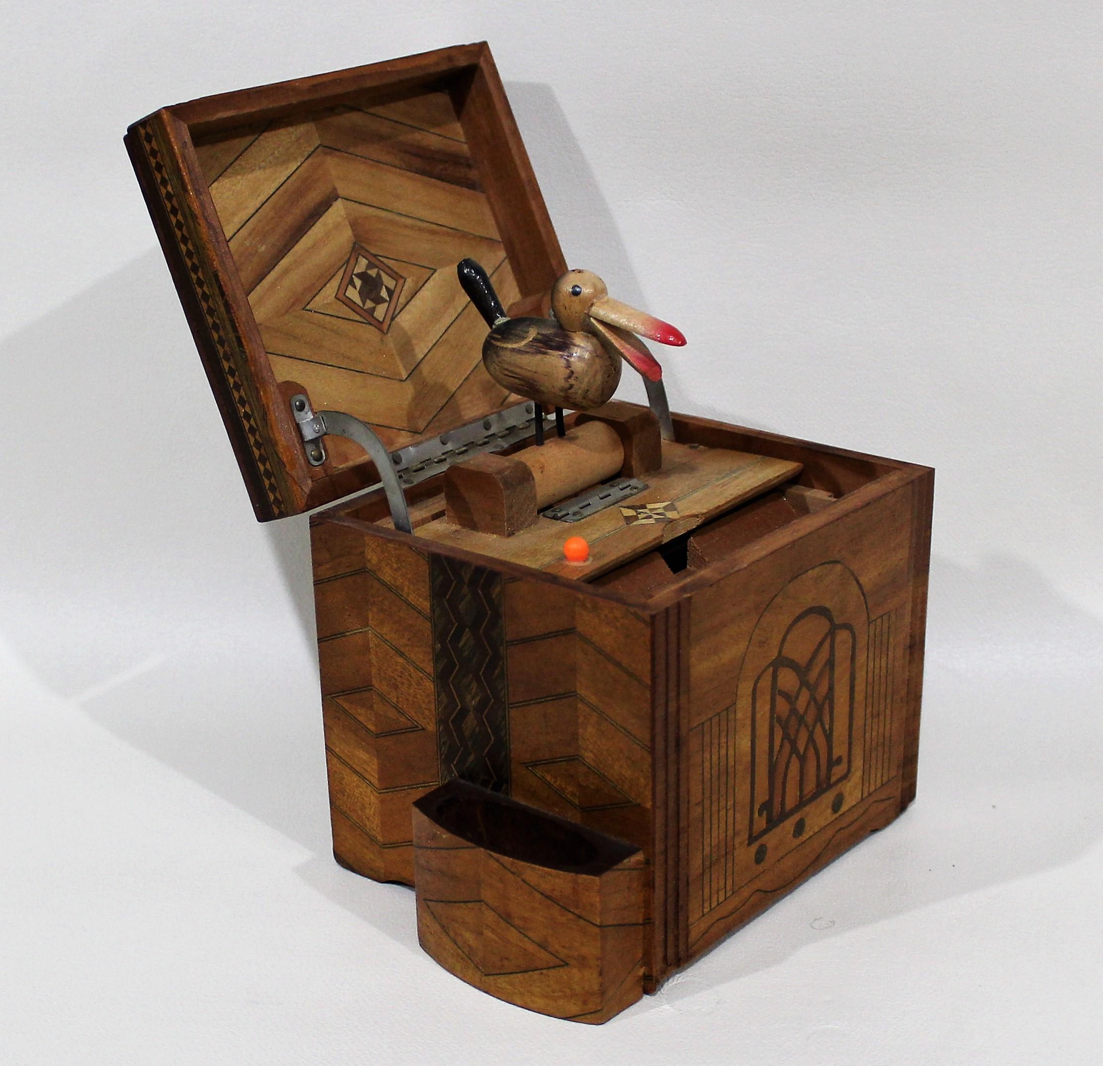 Folk Art mechanical cigarette dispenser box. Marquetry inlaid box which stores cigarettes and when you open the box the bird pops up with a cigarette in its beak.