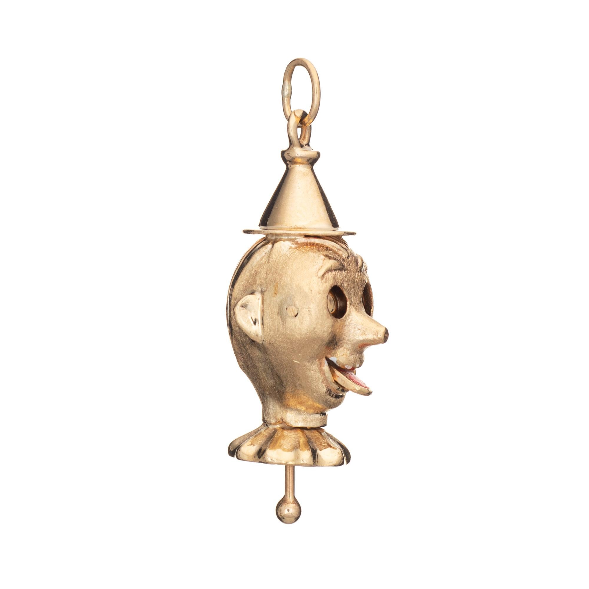 Finely detailed vintage mechanical clown charm crafted in 14k yellow gold (circa 1950s to 1960s).  

The distinct and unusual clown features movable eyes and a tongue, activated at the base with a stem (push and pull motion activates the eyes and