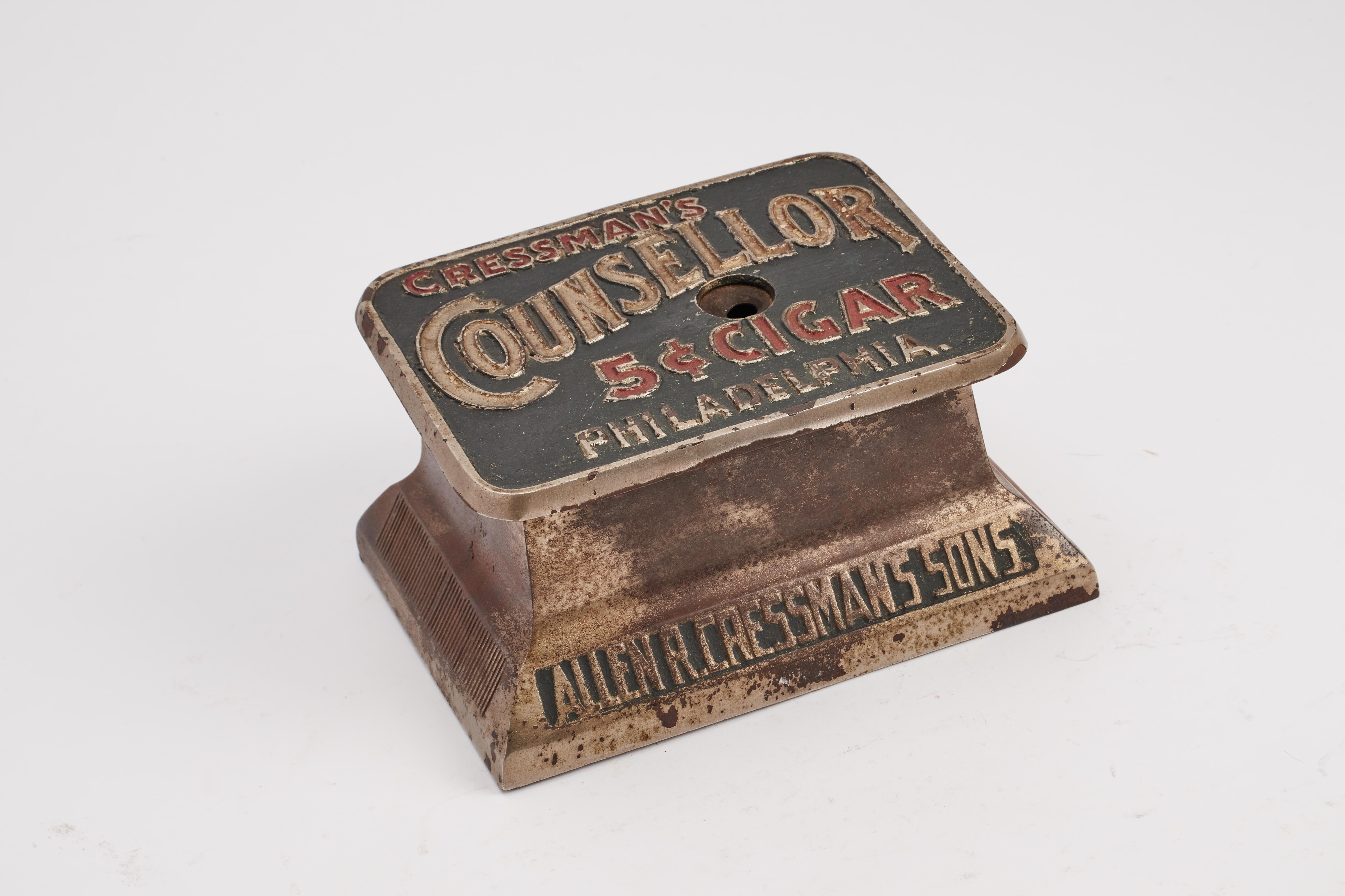 Coupe-cigares mécanique pour comptoir de tabac avec mécanisme à ressort pour couper les cigares à 5 centimes au moment de la vente. Fabriqué en métal chromé et en émail. Allen R. Cressmans Sons. Philadelphie, États-Unis, fin du XIXe siècle.