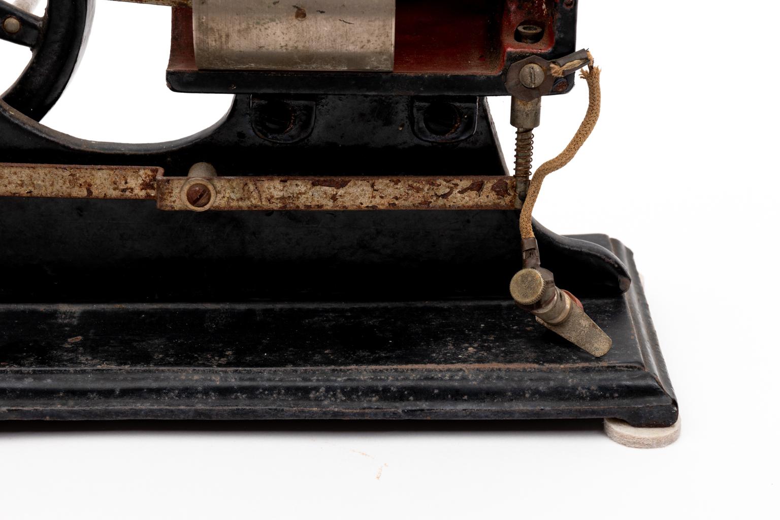 Circa 20th century working antique iron and wood steam engine piston model for classroom use by a teacher. It features a cut-a-way side to exhibit the piston moving and a small valve at the end which moves up and down. The piston model stands on a