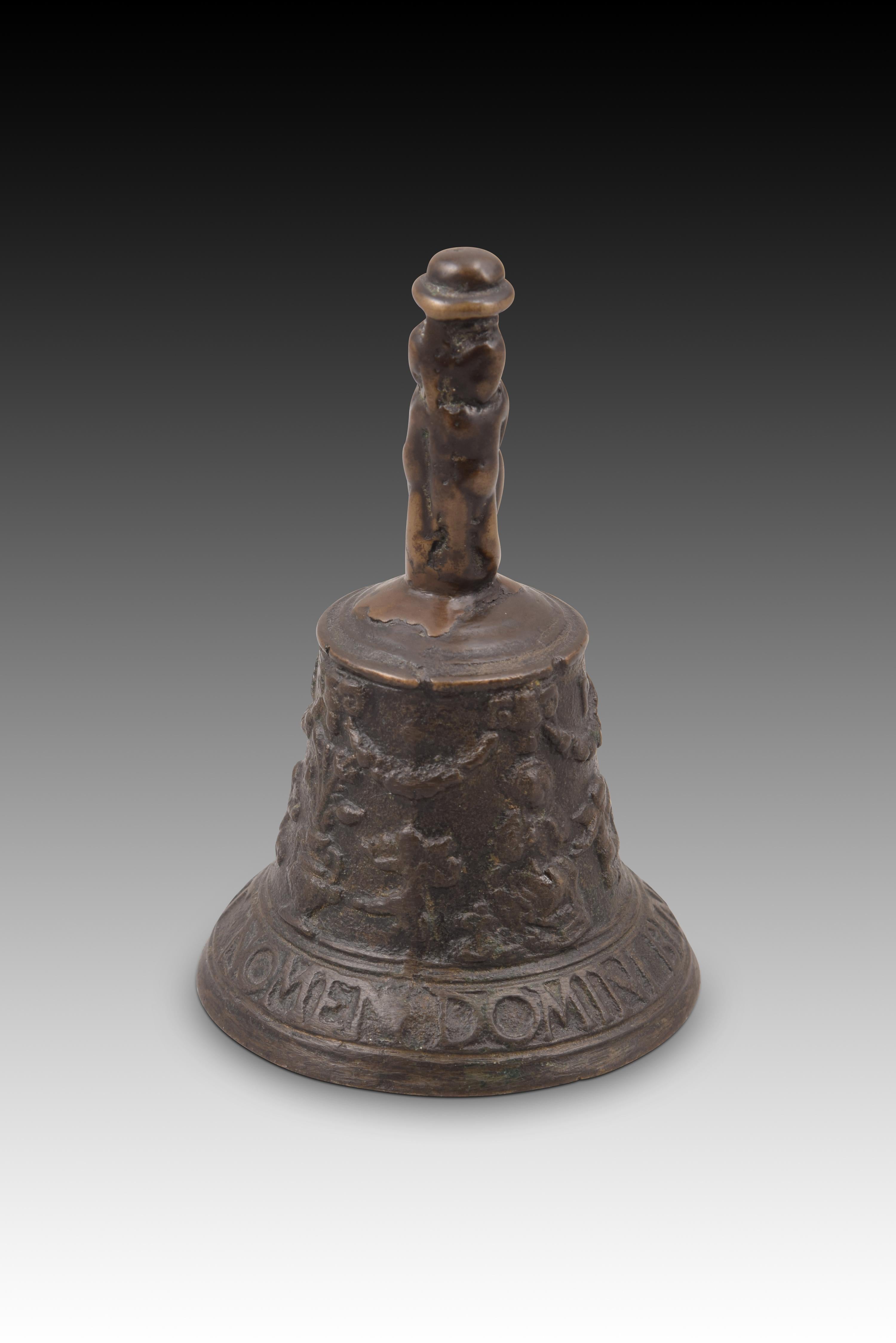 Flemish bell, “from Mechelen”. Bronze. Century XVI. 
Hand bell with clapper made of bronze and decorated on the outside with a slight relief. The base presents, between bands, an inscription in capital letters and in Latin (“Sit nomen Domini