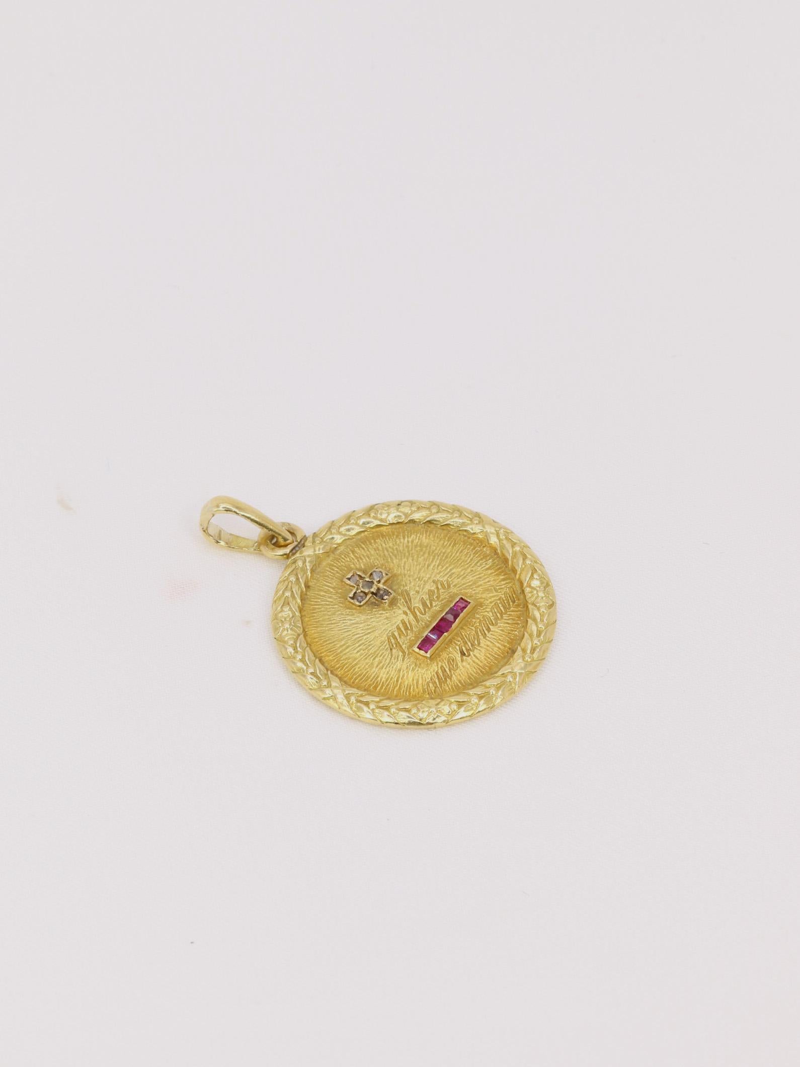Médaille amour Augis ronde en or, diamants et rubis ca. 1910, Plus qu’hier moins que demain

Médaille Amour en or jaune 18k (750°/°°) sertie de 5 rubis synthétiques et 5 diamants taille rose. La médaille est entourée d'un motif fleuri
