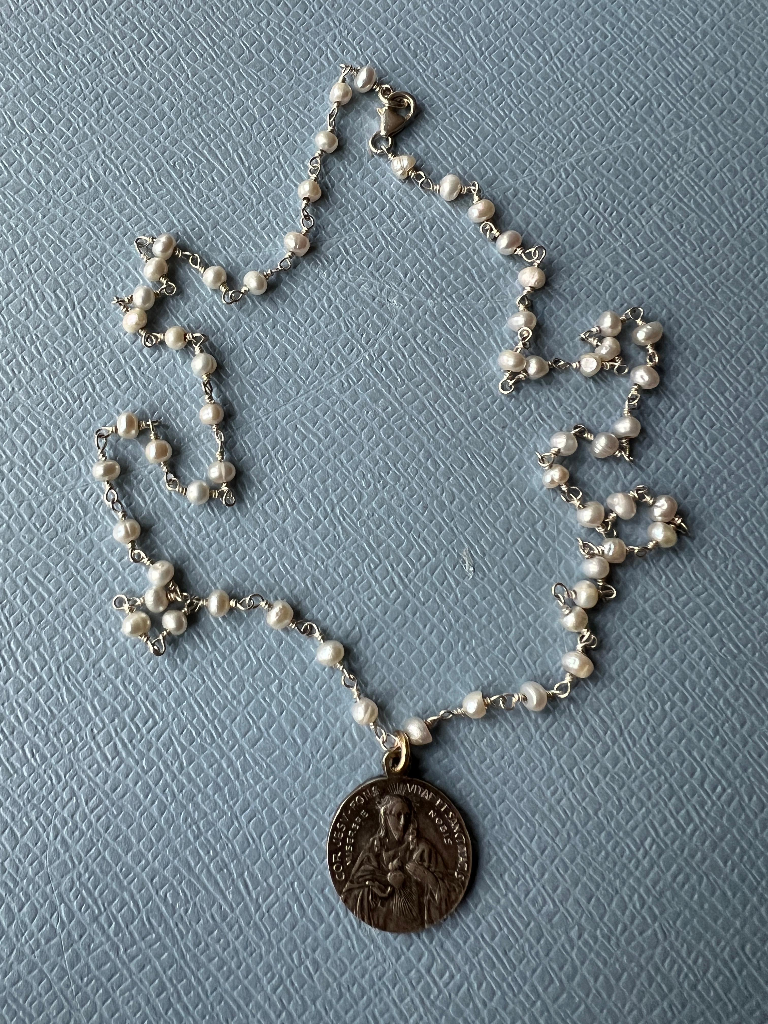 Medal Necklace White Pearl Silver Rosario with a Vintage French Medal with Jesus Heart 

Vintage possibly Antique French Medal featuring Jesus with heart on one side and on the other side Jesus being carried, the medal has an old silver plating and