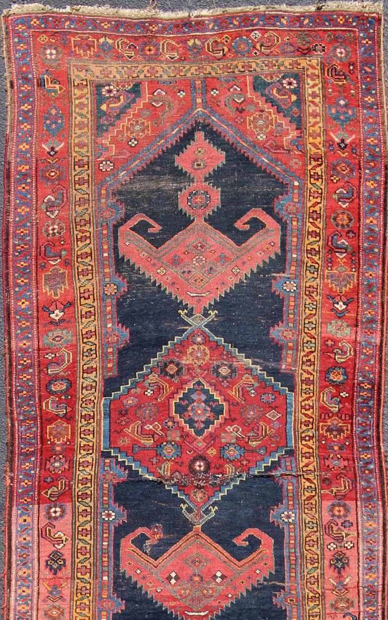Blue and red medallion design Persian antique Kurdish runner, rug 19-0106, country of origin / type: Iran / Kurdish, circa 1900.

This antique Kurdish tribal rug was woven by Kurdish weavers in western Persia. Often they used this repeating design