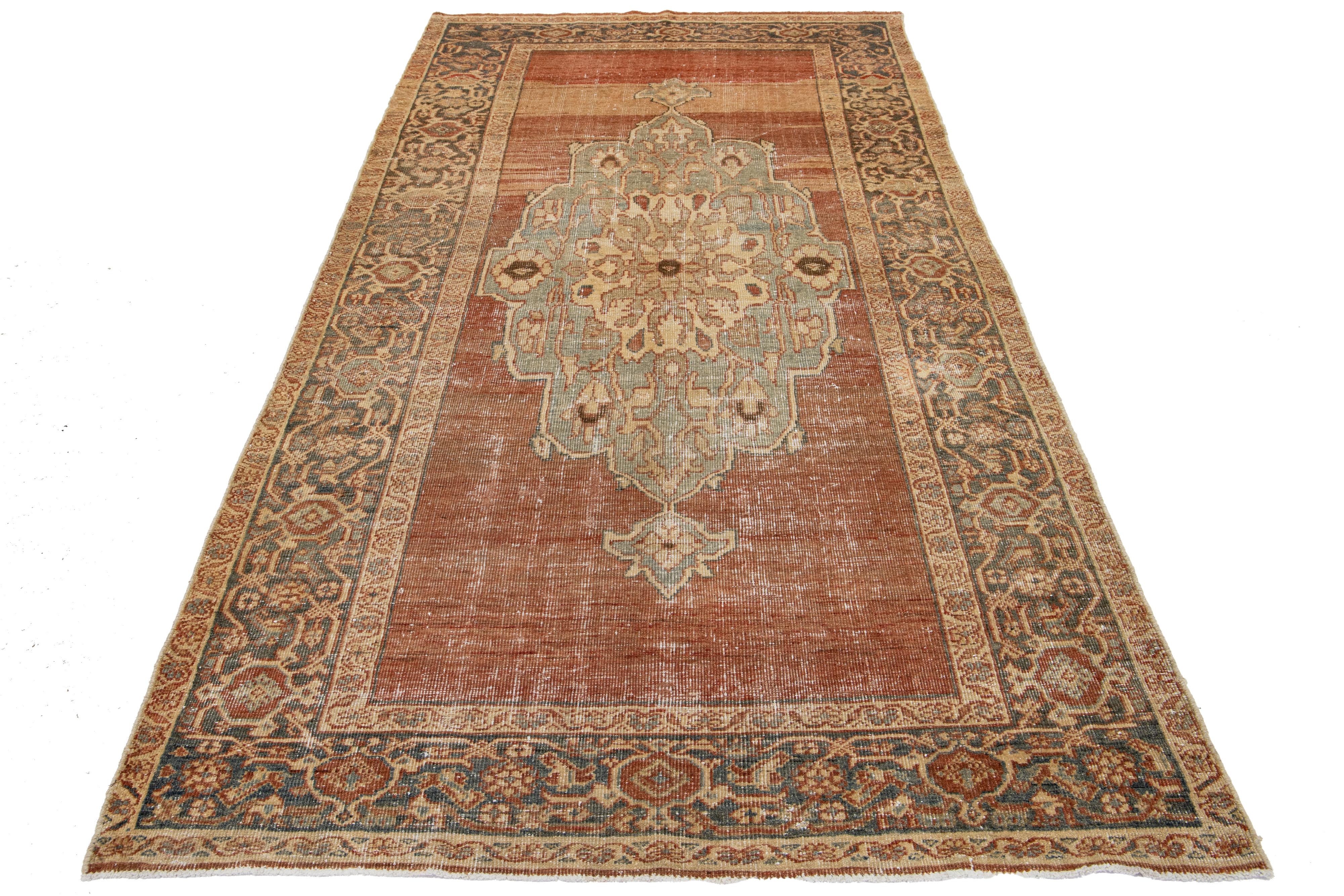 Hand-knotted wool Persian rug featuring a rust-colored field with a blue, gray, and beige medallion motif.

This rug measures 5'1