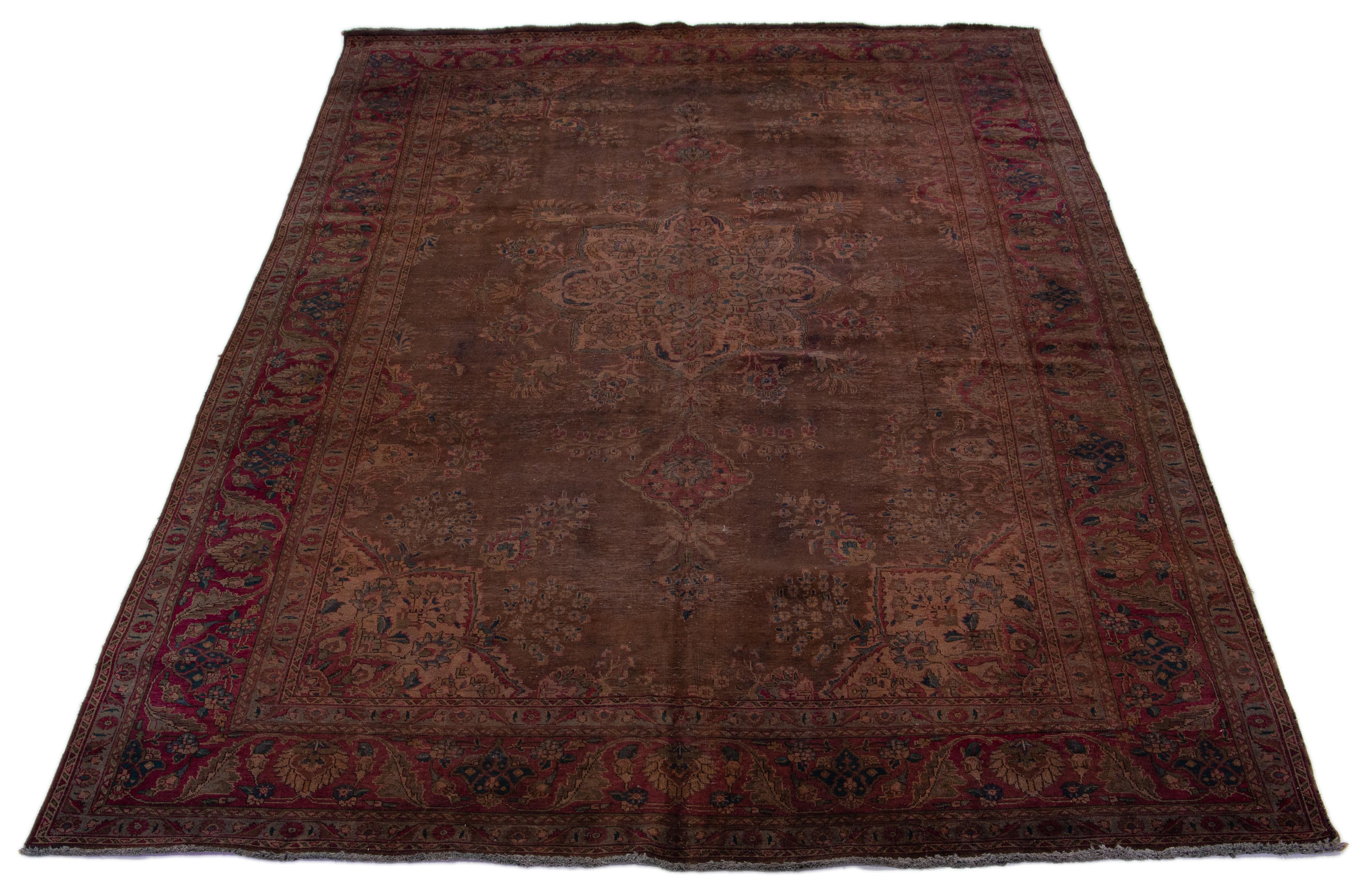 This Persian carpet from the 1950s features a medallion design in the center and has been distressed and overdyed for a vintage look. Its rich brown hue lends a luxurious elegance to any room.

This rug measures 9'10