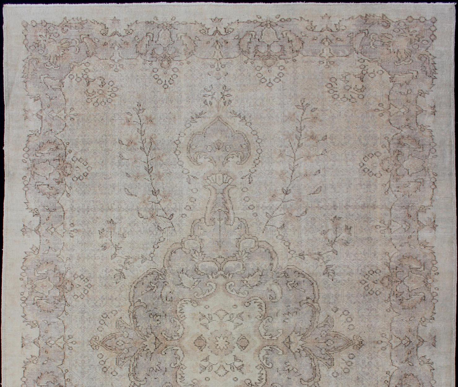   Keivan Woven Arts Vintage Turkish Distressed Rug in Sand, Cream, lavender, Taupe with brown highlights 

Measures:6'7 x 10'5  

Sand, Taupe, cream and light lavender distressed vintage rug from Turkey with medallion design of etched motifs, keivan