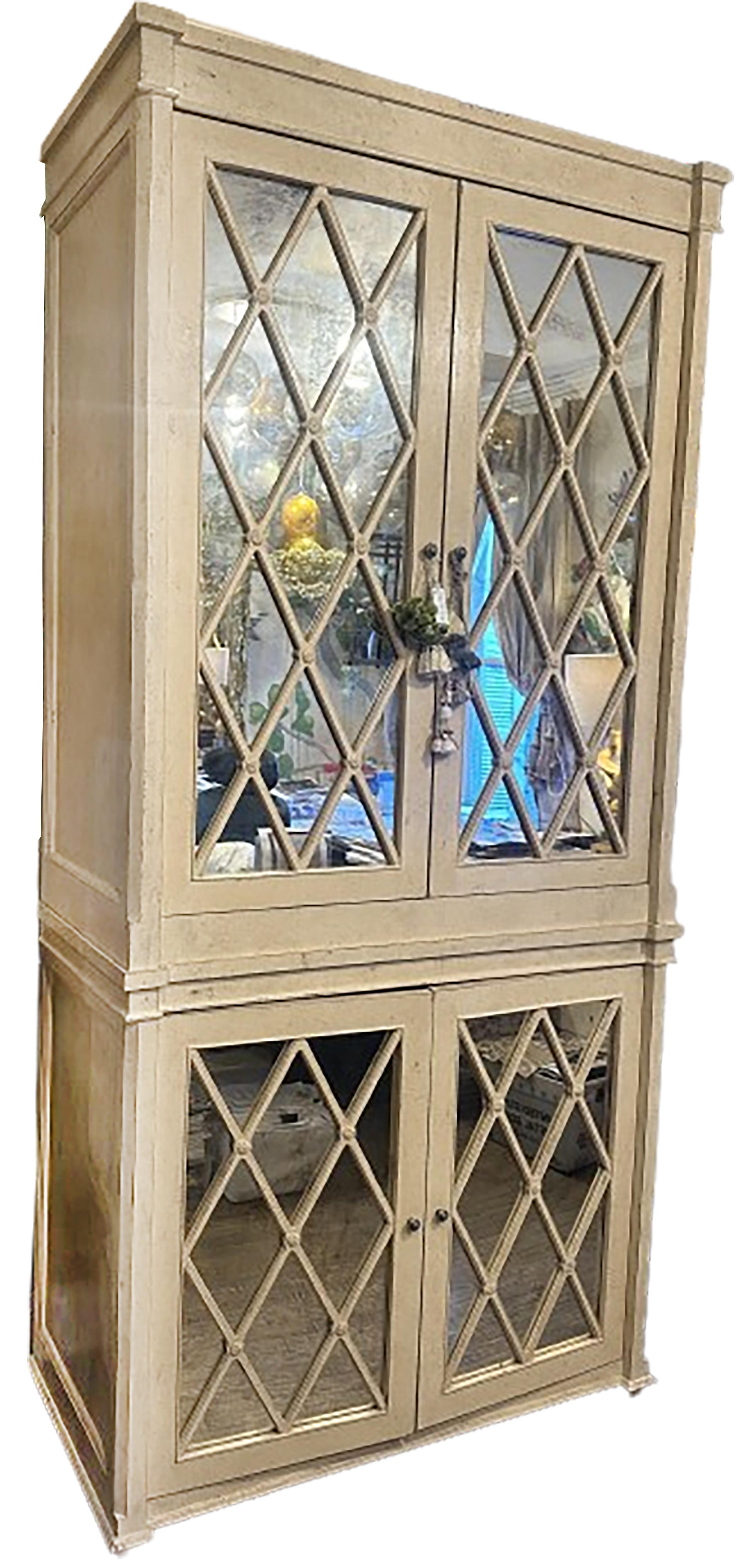 A handsome media armoire with mirrored cabinet doors. A mixture of classical English and modern influences. Metal handles on top and bottom. The TV tray extends out and swivels from the top cabinet. Wood trim cut in diamond shape repeated with glass