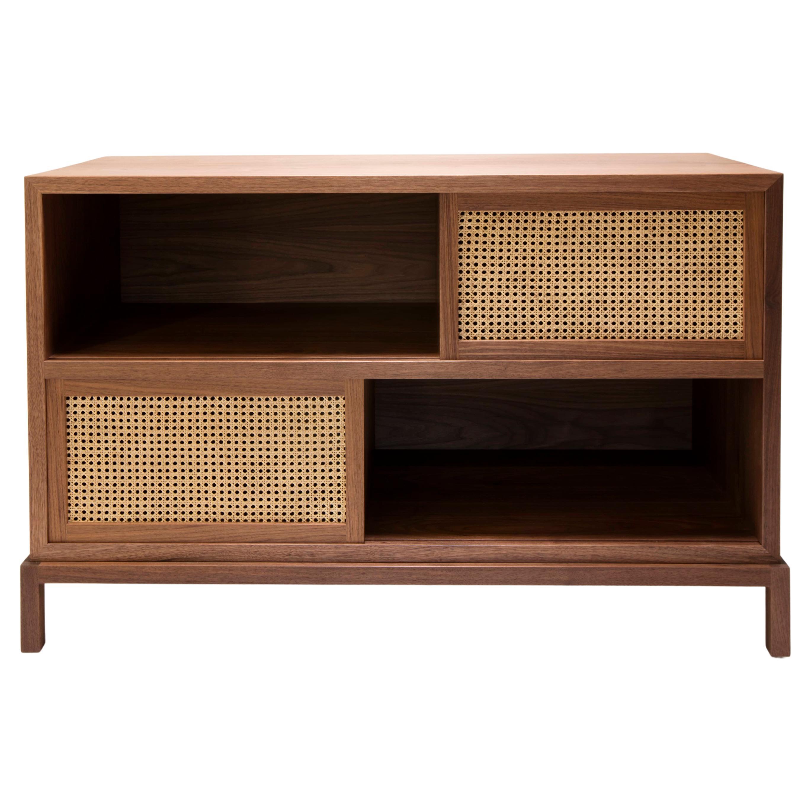 This media cabinet in solid walnut with sliding cane doors was originally designed so that a receiver could be hidden behind the cane doors and still be controlled with a remote. We have since built it for a wide variety of uses, generally