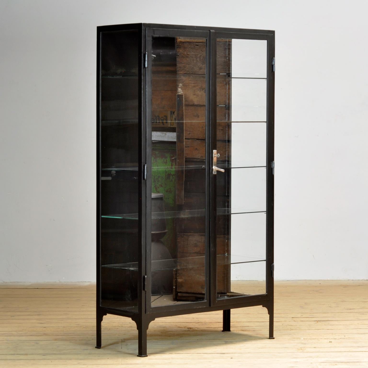 Gabinete médico de los años 30. El mueble se fabrica en Hungría y está hecho de hierro grueso y cristal. La cerradura y la empuñadura son originales y funcionales.

El mueble se ha repintado recientemente en negro mate.