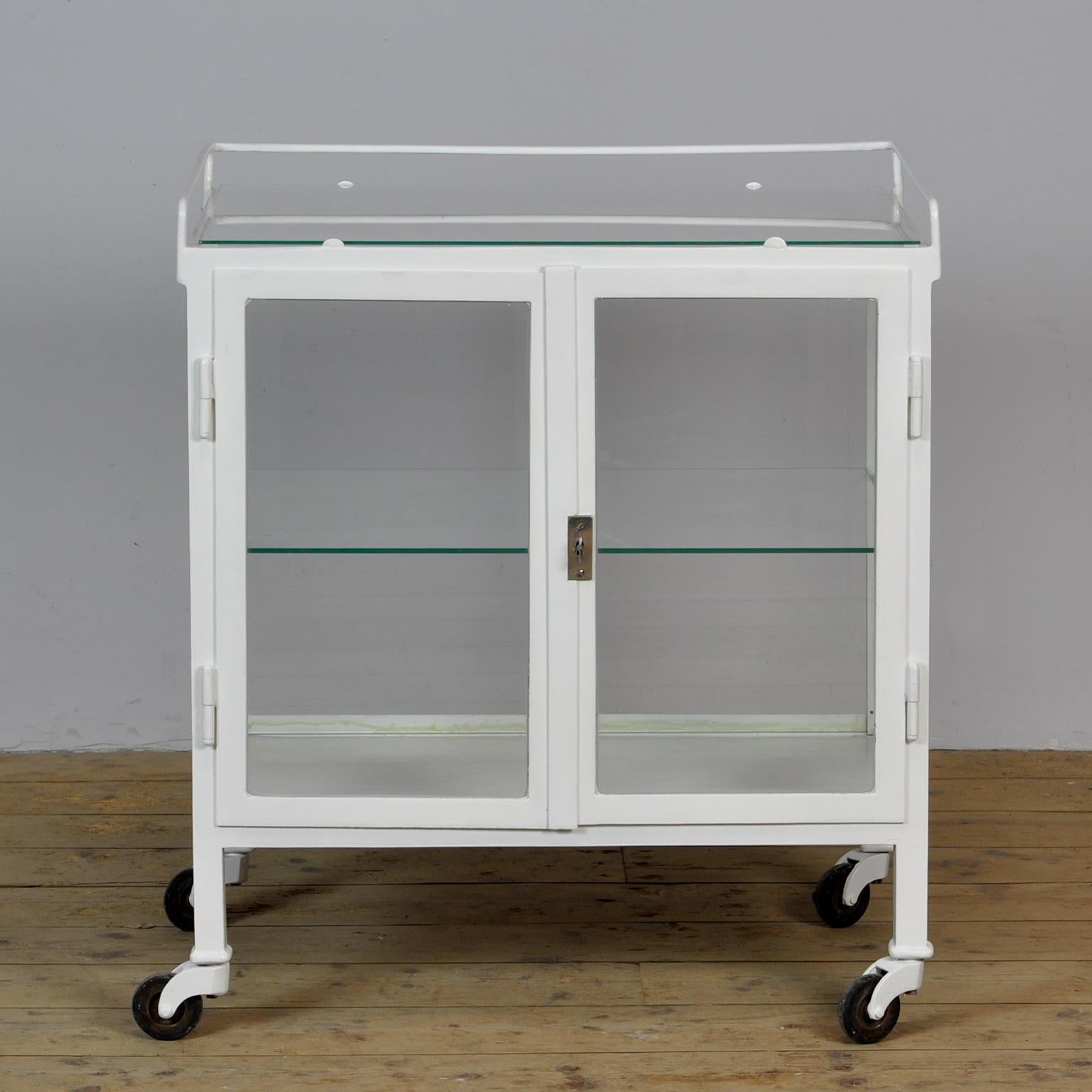 Medical trolley made of thick iron and glass. Produced in the 30s. The cabinet has glass on 4 sides. On top of a glass plate. Good working lock / key.
The trolley has been repainted recently.