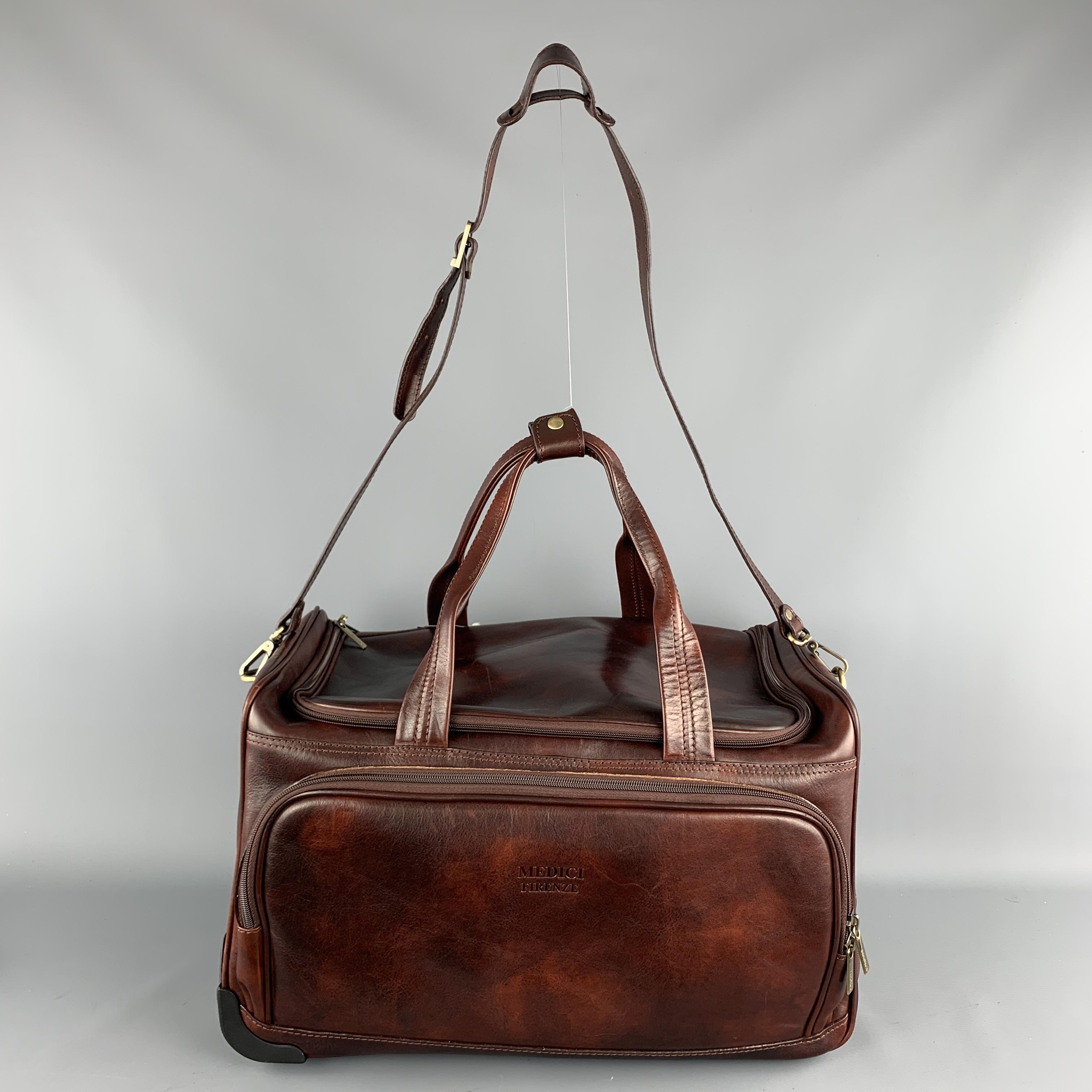 MEDICI Duffle Rectangle Bag comes in a solid brown leather material, with a zip closure at top, top handle, zip front back and side pockets, a branded lining, inner pockets, and adjustable shoulder strap. Very light wear throughout. 

Very Good