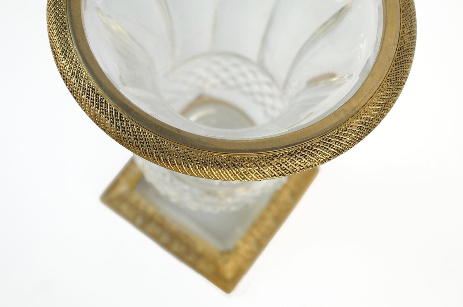 Medici vase in diamond cut crystal on the bugle and with facets on the neck. Edge in gilt bronze decorated with cables. Square base in cut crystal and gilt bronze decorated with acanthus leaves.

Work realized in the 1950s.